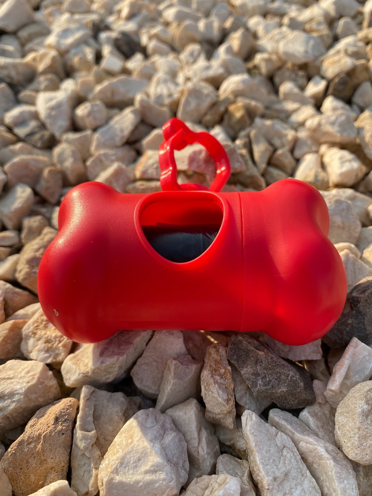 DogBone Poop Bag Dispenser in various colors with bags attached, designed for easy cleanup during dog walks.