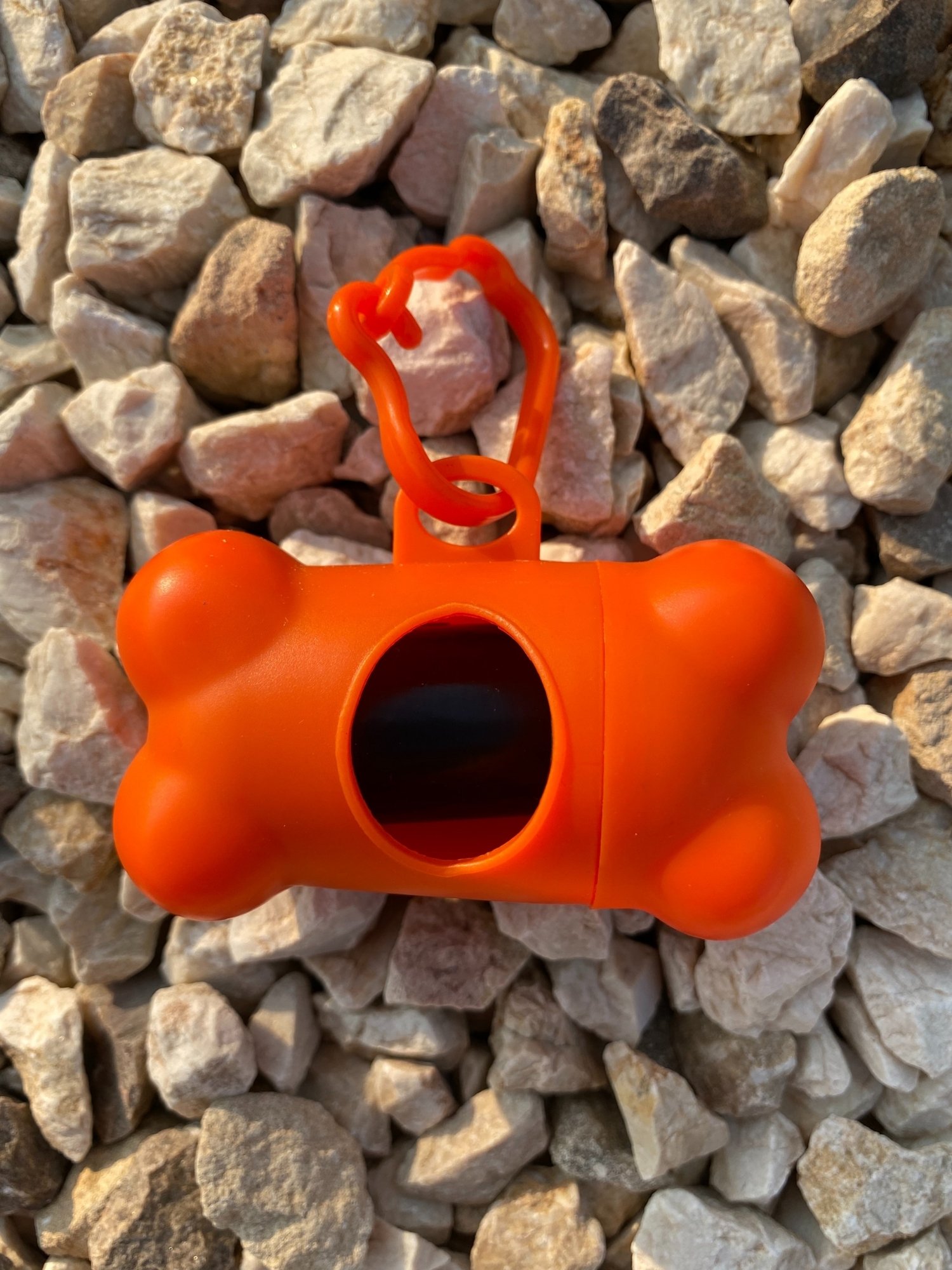 DogBone Poop Bag Dispenser in various colors with bags attached, designed for easy cleanup during dog walks.