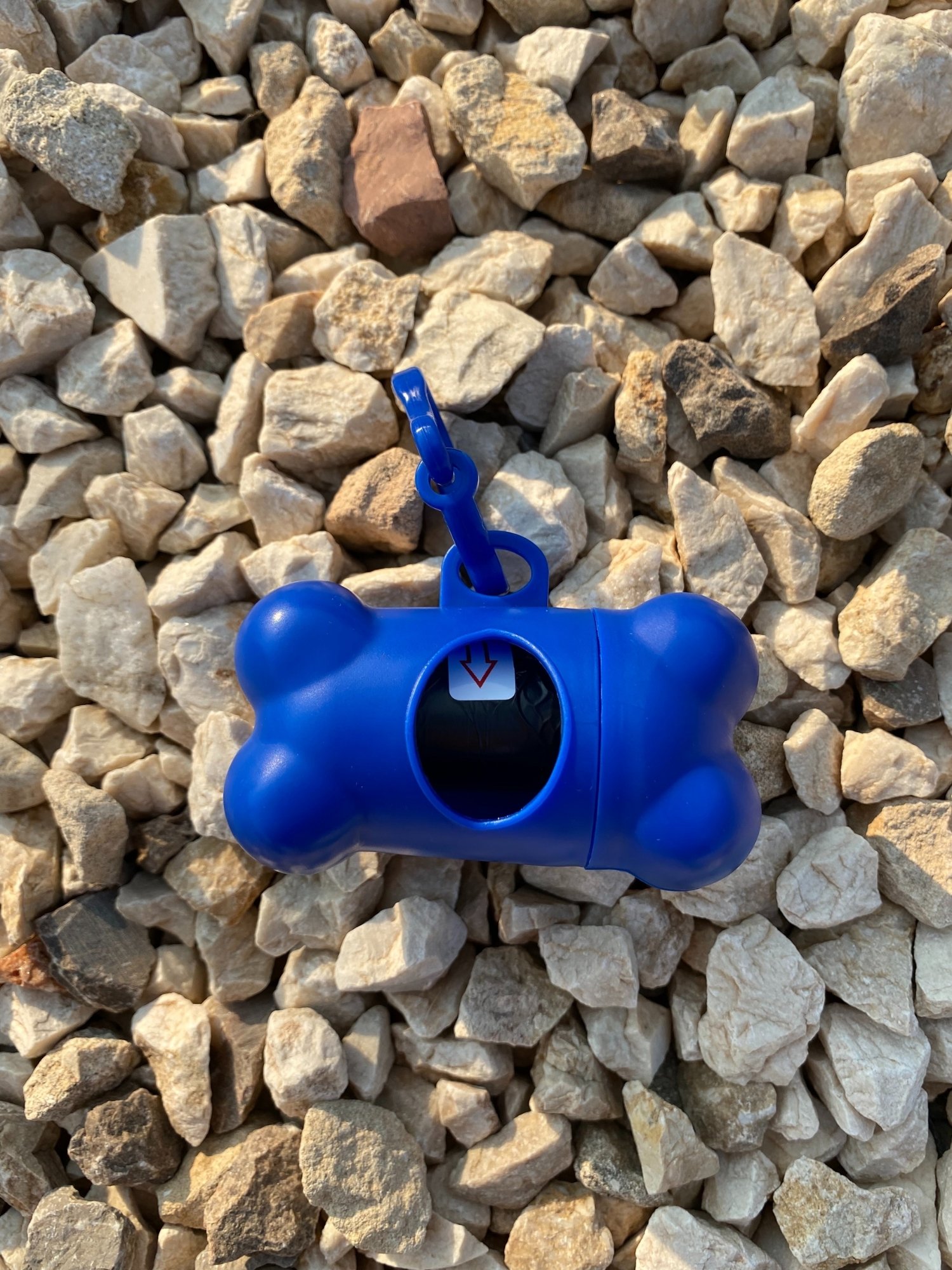 DogBone Poop Bag Dispenser in various colors with bags attached, designed for easy cleanup during dog walks.