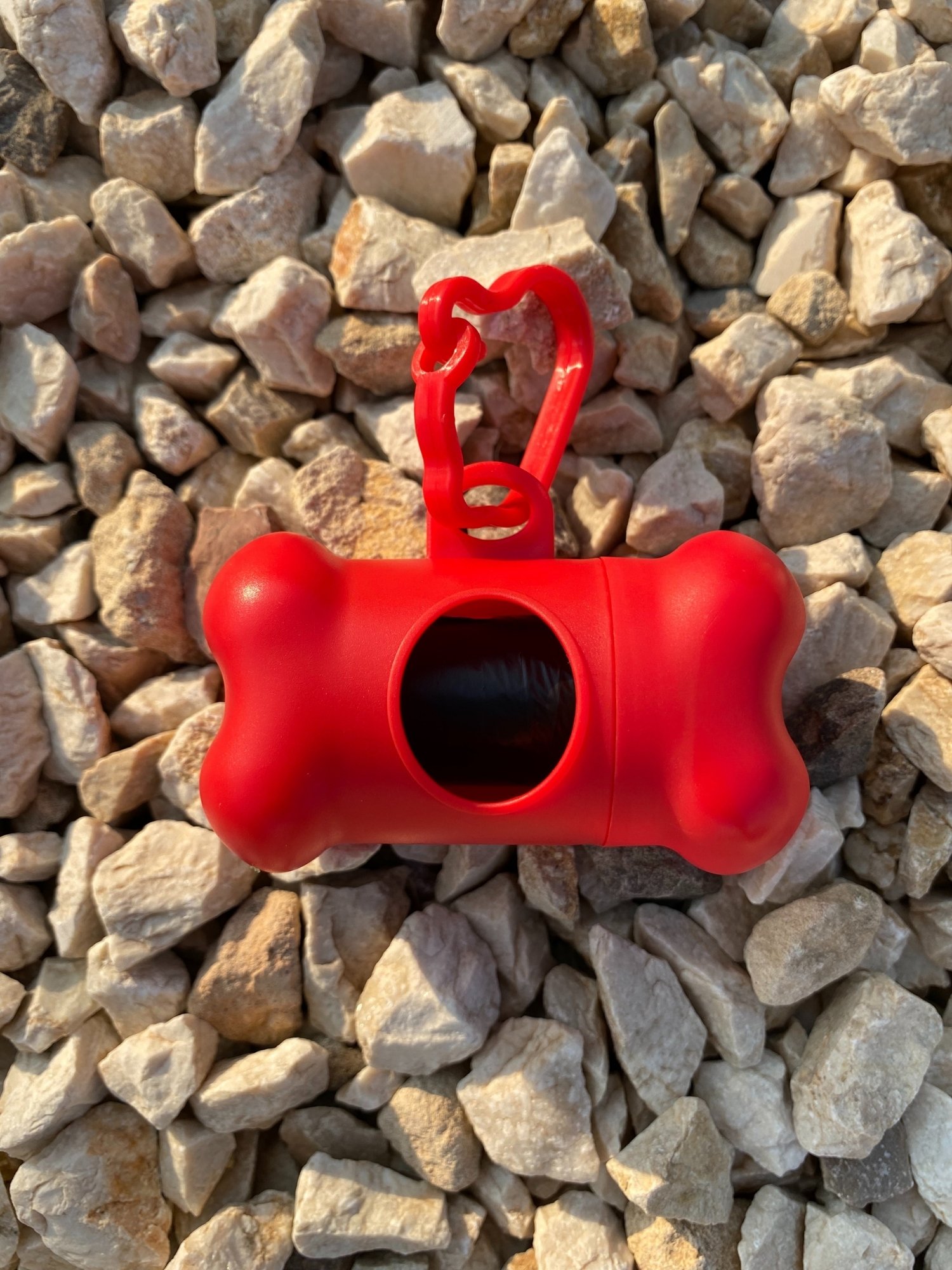 DogBone Poop Bag Dispenser in various colors with bags attached, designed for easy cleanup during dog walks.