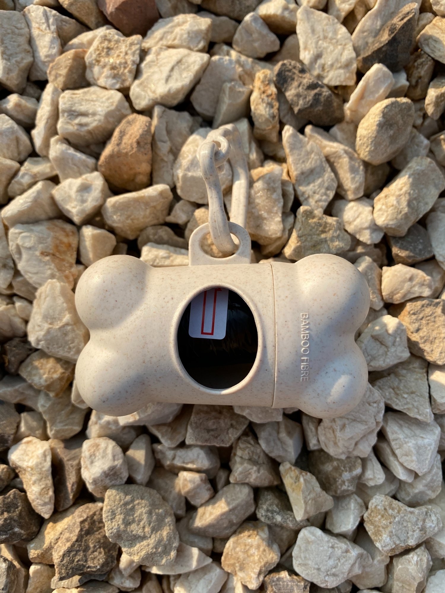 DogBone Poop Bag Dispenser in various colors with bags attached, designed for easy cleanup during dog walks.