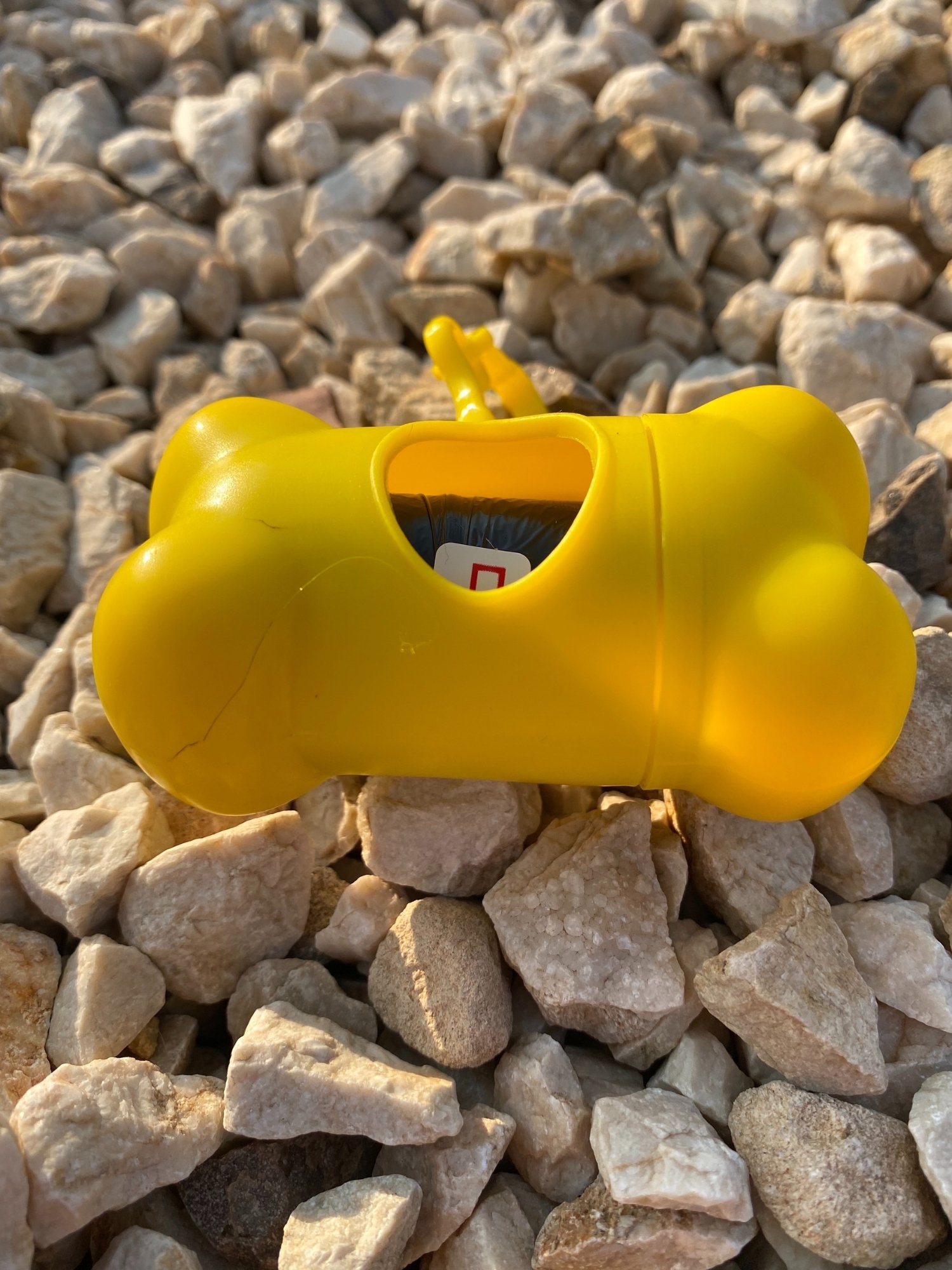 DogBone Poop Bag Dispenser in various colors with bags attached, showcasing its design and functionality.