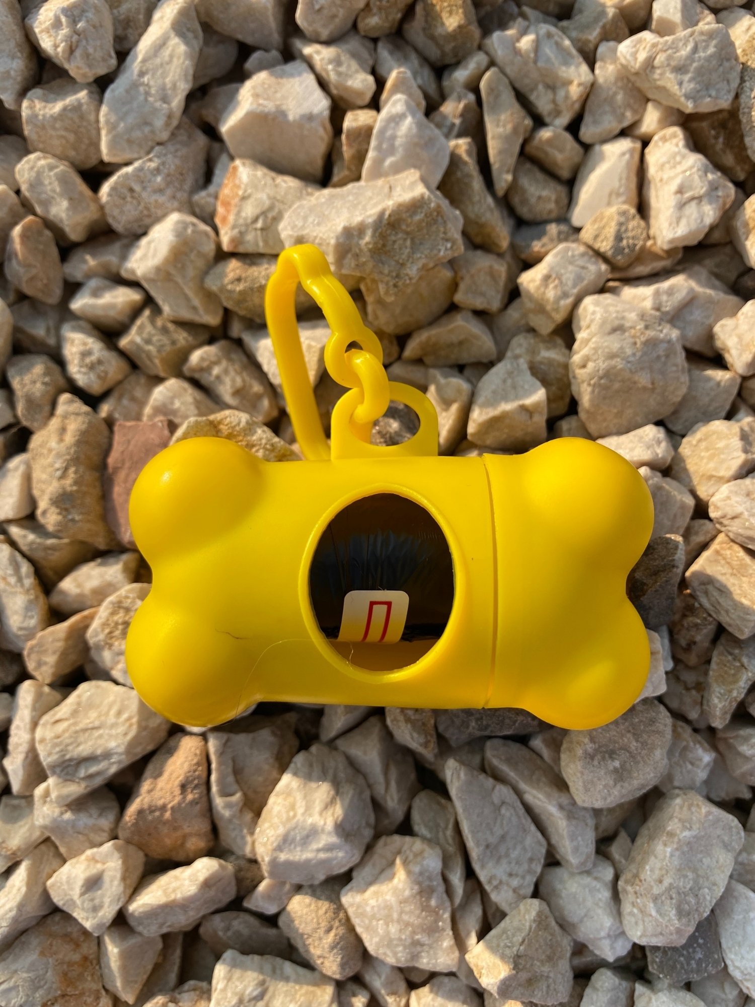 DogBone Poop Bag Dispenser in various colors with bags attached, showcasing its design and functionality.