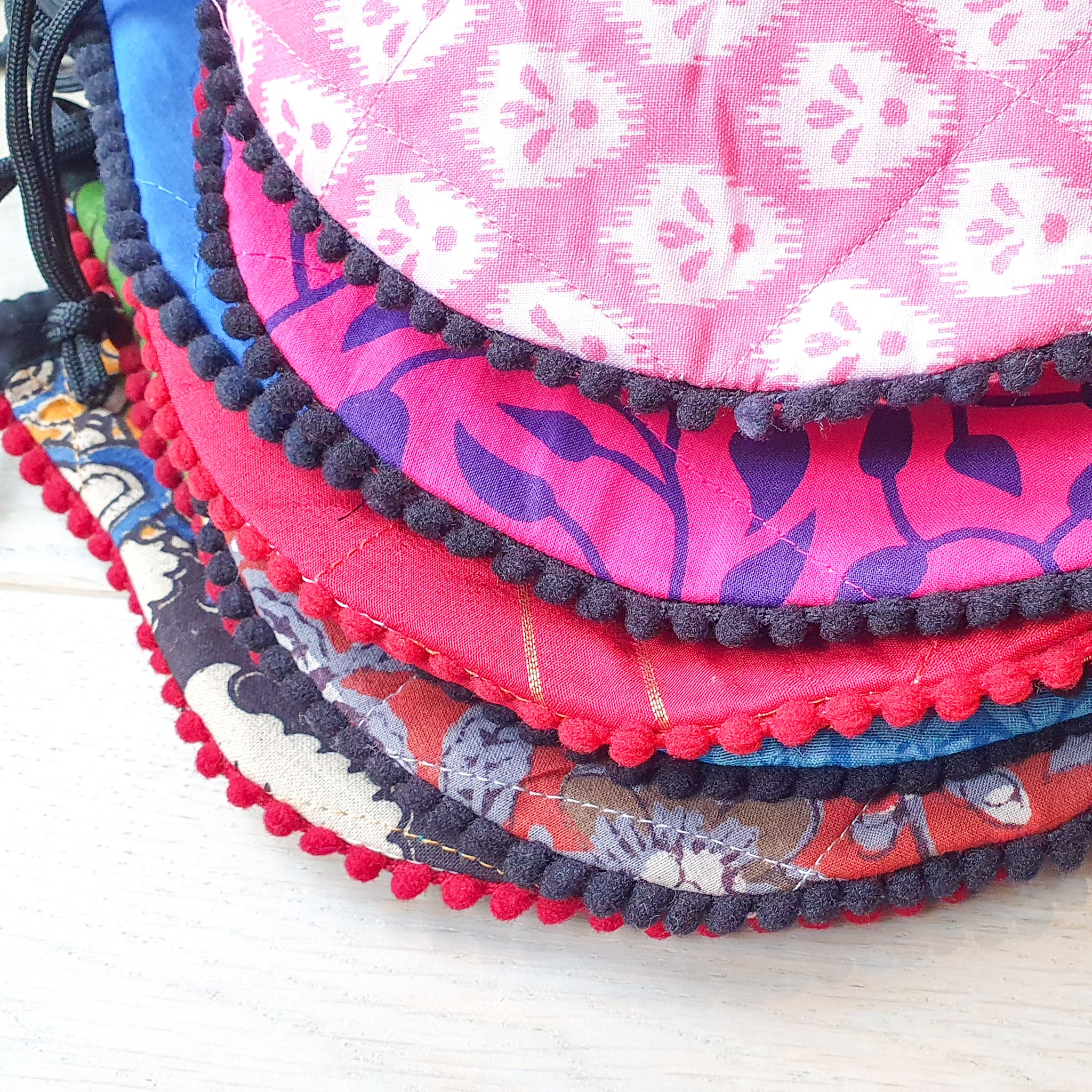 A colorful handcrafted drawstring sari pouch showcasing unique patterns and vibrant colors, perfect for storing small items.