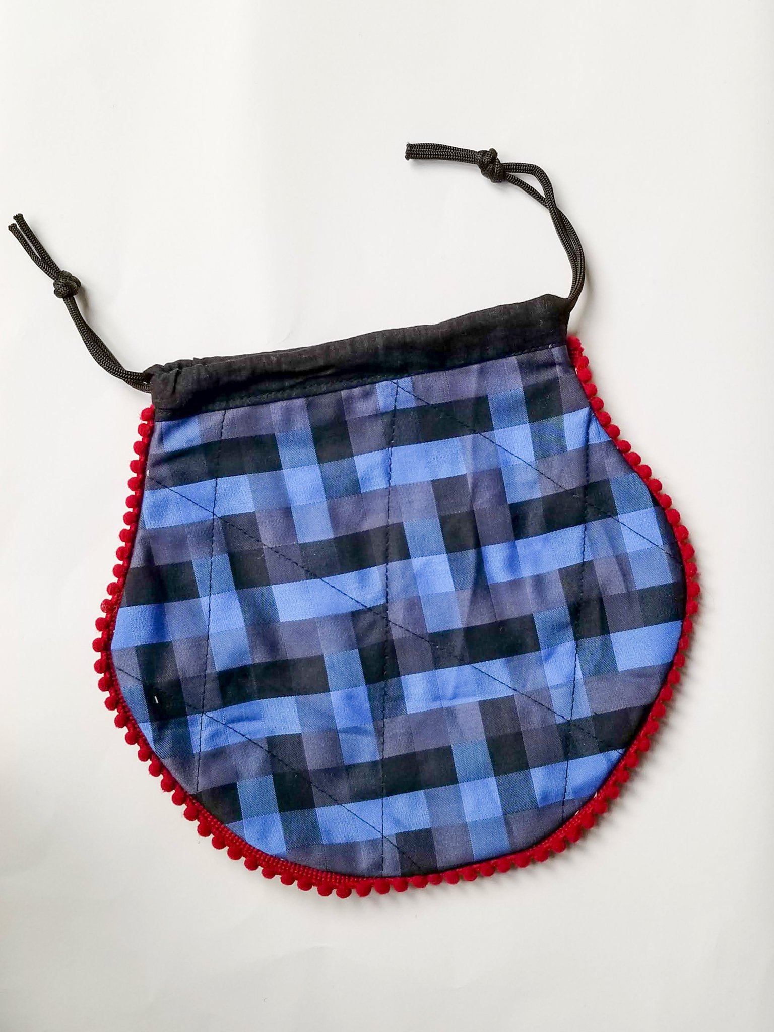 A colorful handcrafted drawstring sari pouch showcasing unique patterns and vibrant colors, perfect for storing small items.