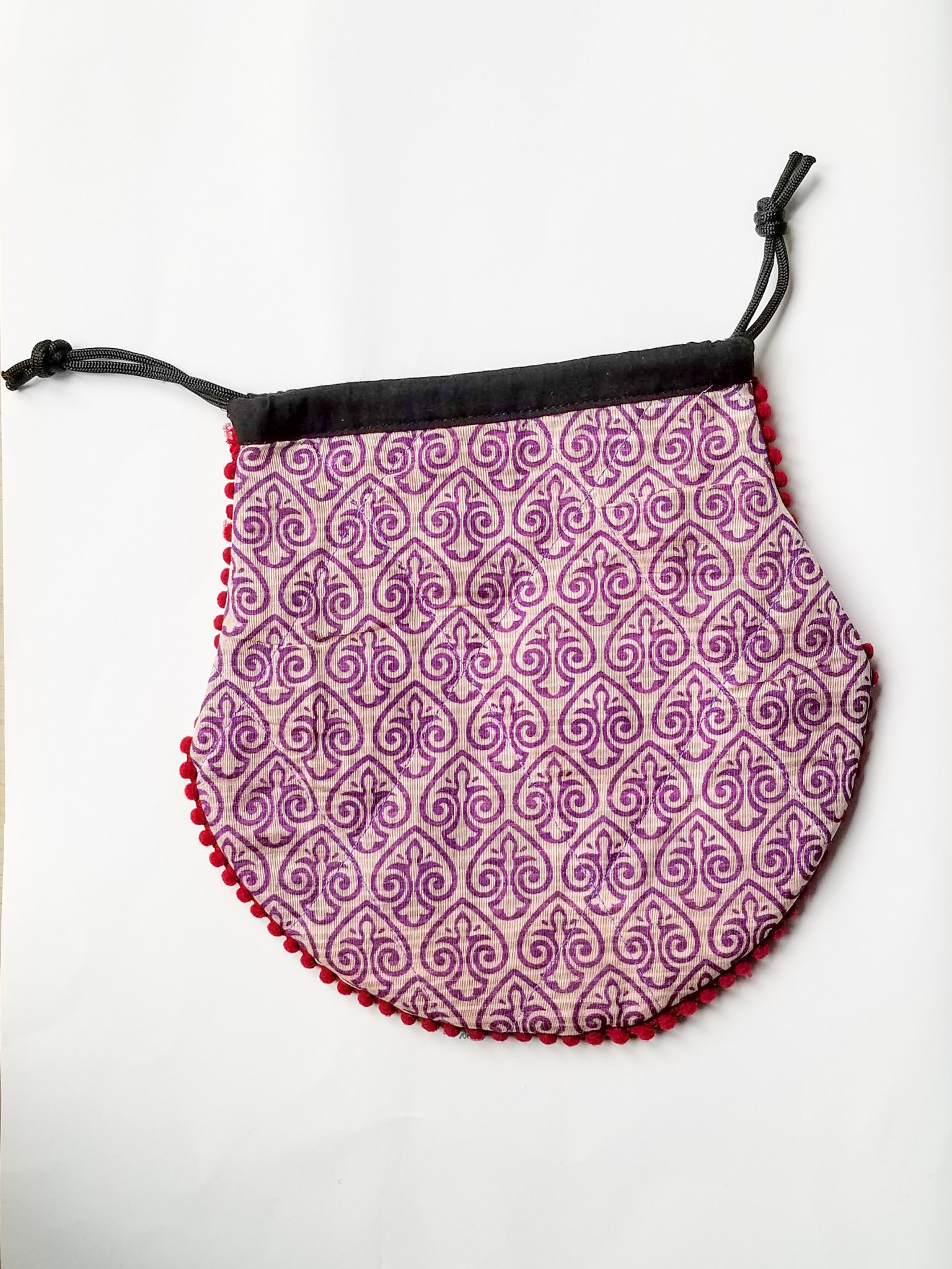 A colorful handcrafted drawstring sari pouch showcasing unique patterns and vibrant colors, perfect for storing small items.