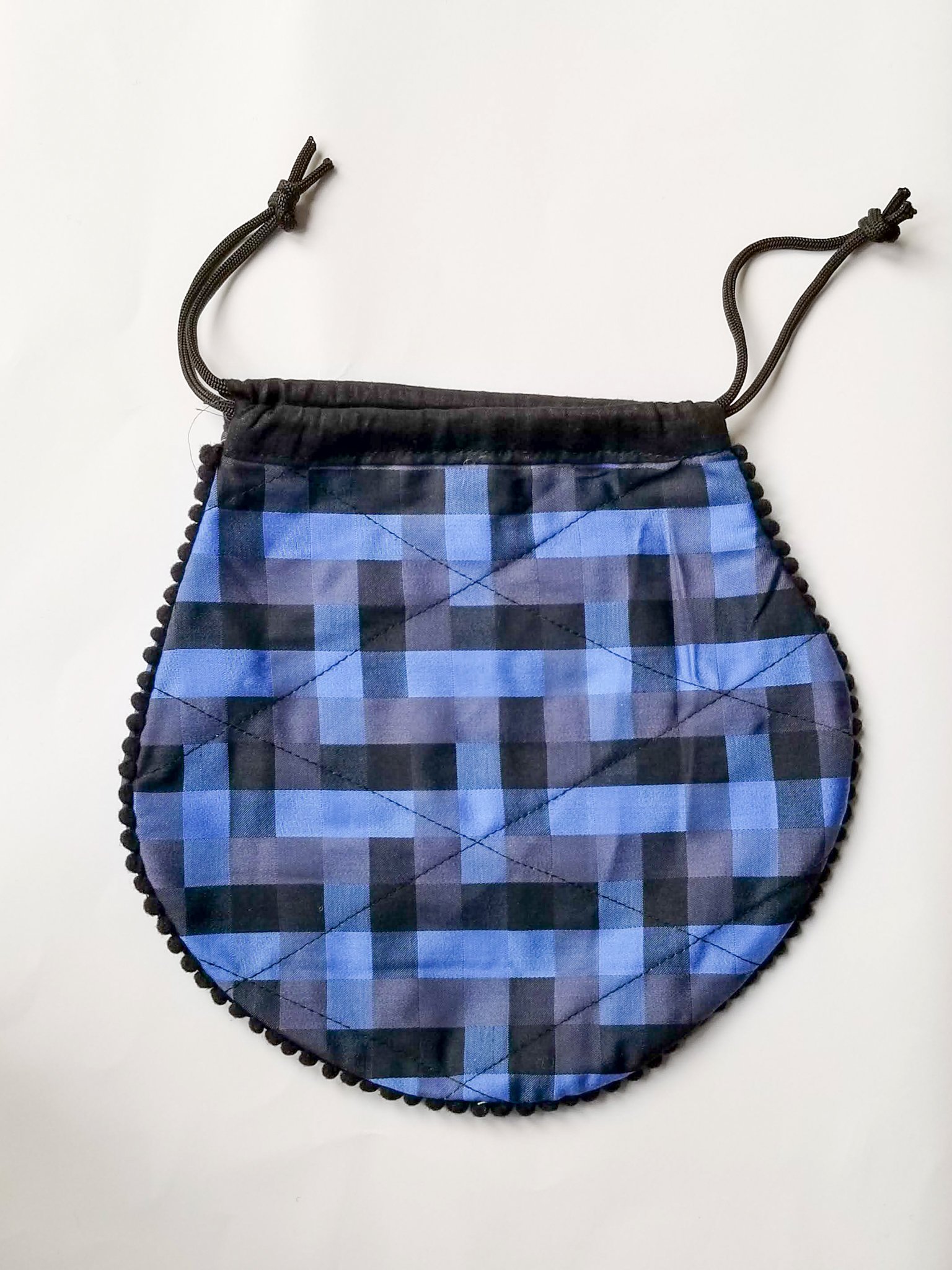 A colorful handcrafted drawstring sari pouch showcasing unique patterns and vibrant colors, perfect for storing small items.