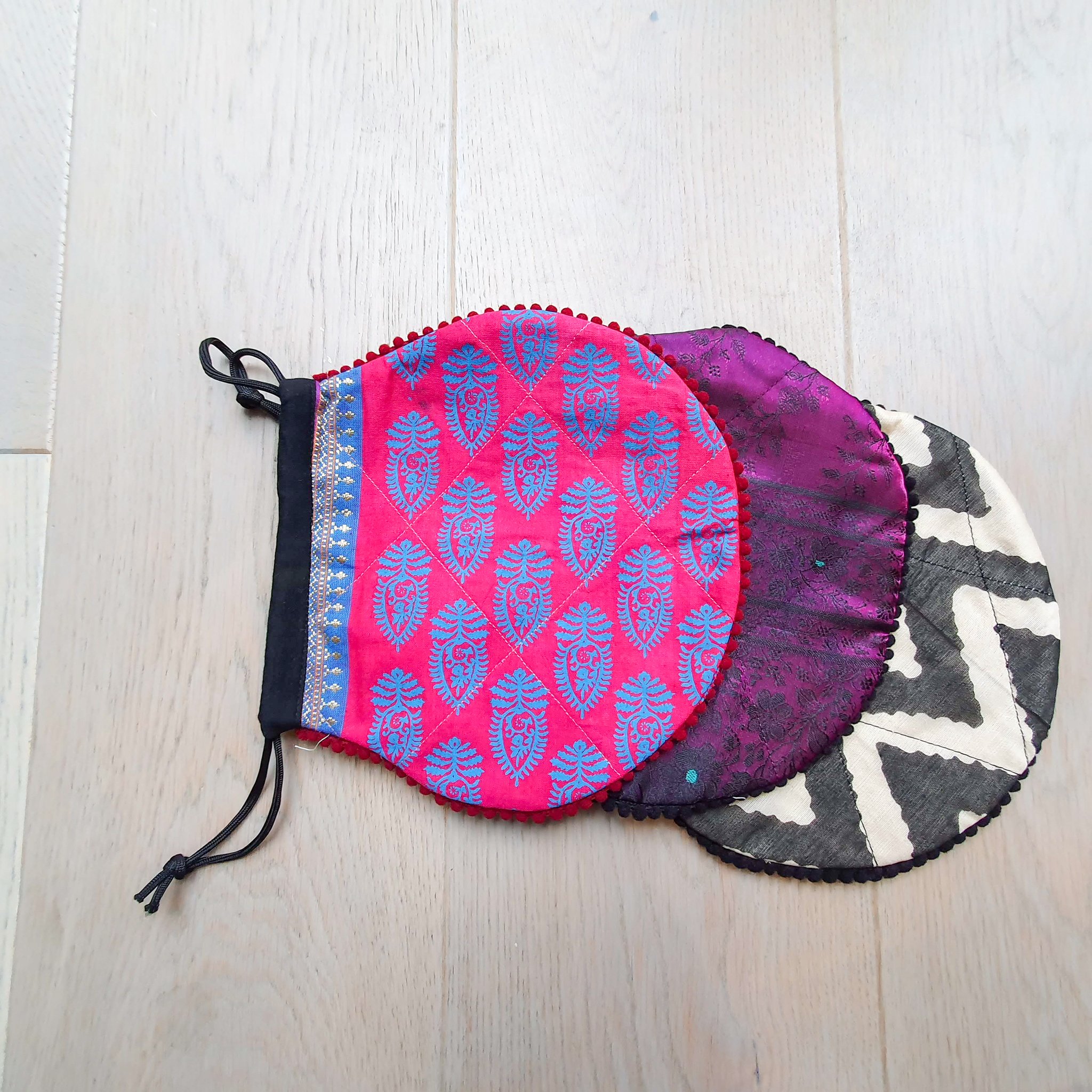 A colorful handcrafted drawstring sari pouch showcasing unique patterns and vibrant colors, perfect for storing small items.