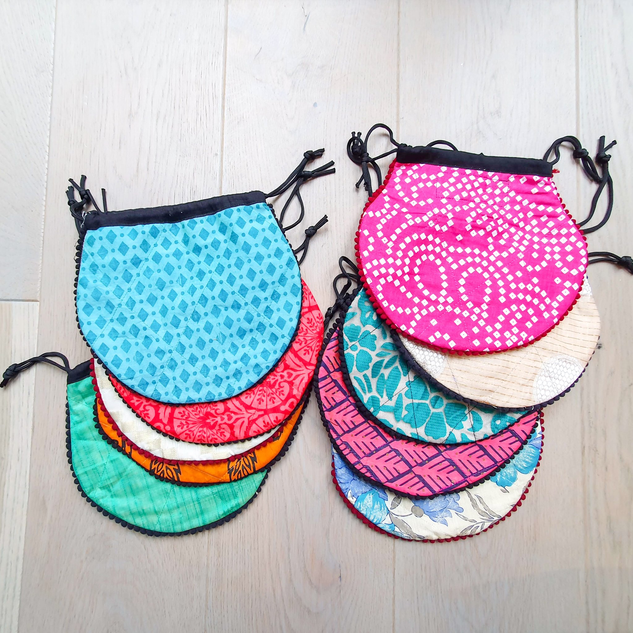 A colorful handcrafted drawstring sari pouch showcasing unique patterns and vibrant colors, perfect for storing small items.