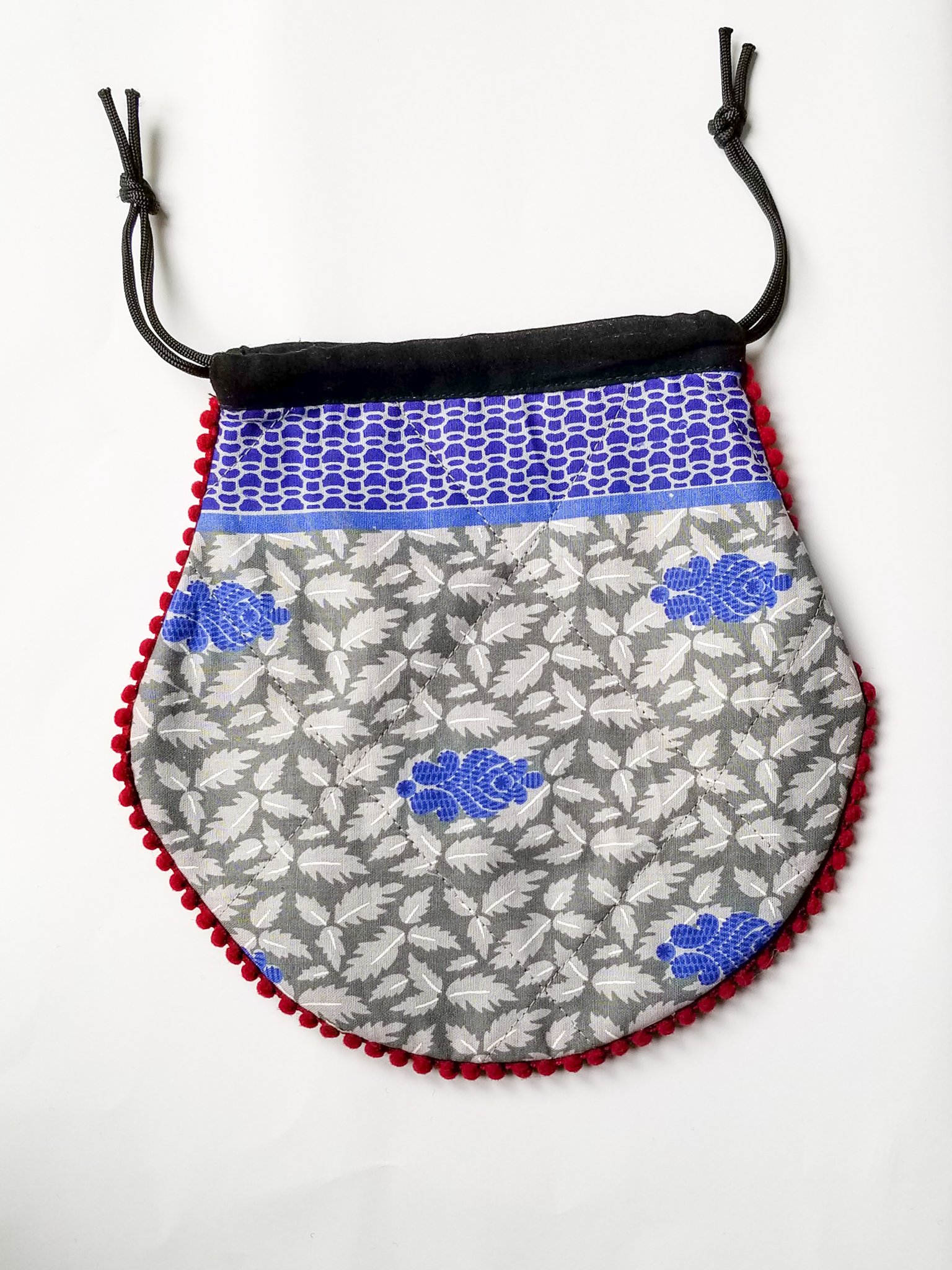 A colorful handcrafted drawstring sari pouch showcasing unique patterns and vibrant colors, perfect for storing small items.