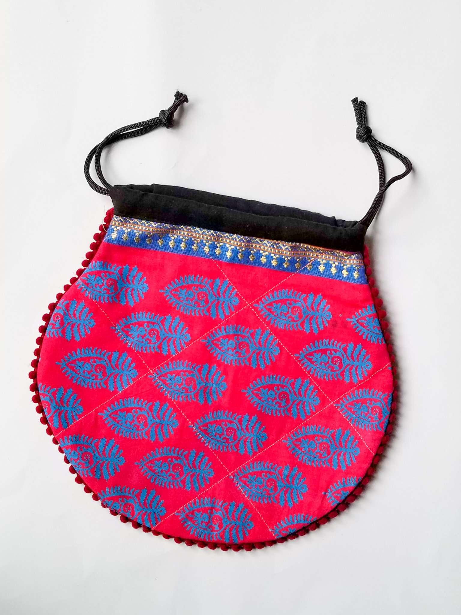 A colorful handcrafted drawstring sari pouch showcasing unique patterns and vibrant colors, perfect for storing small items.