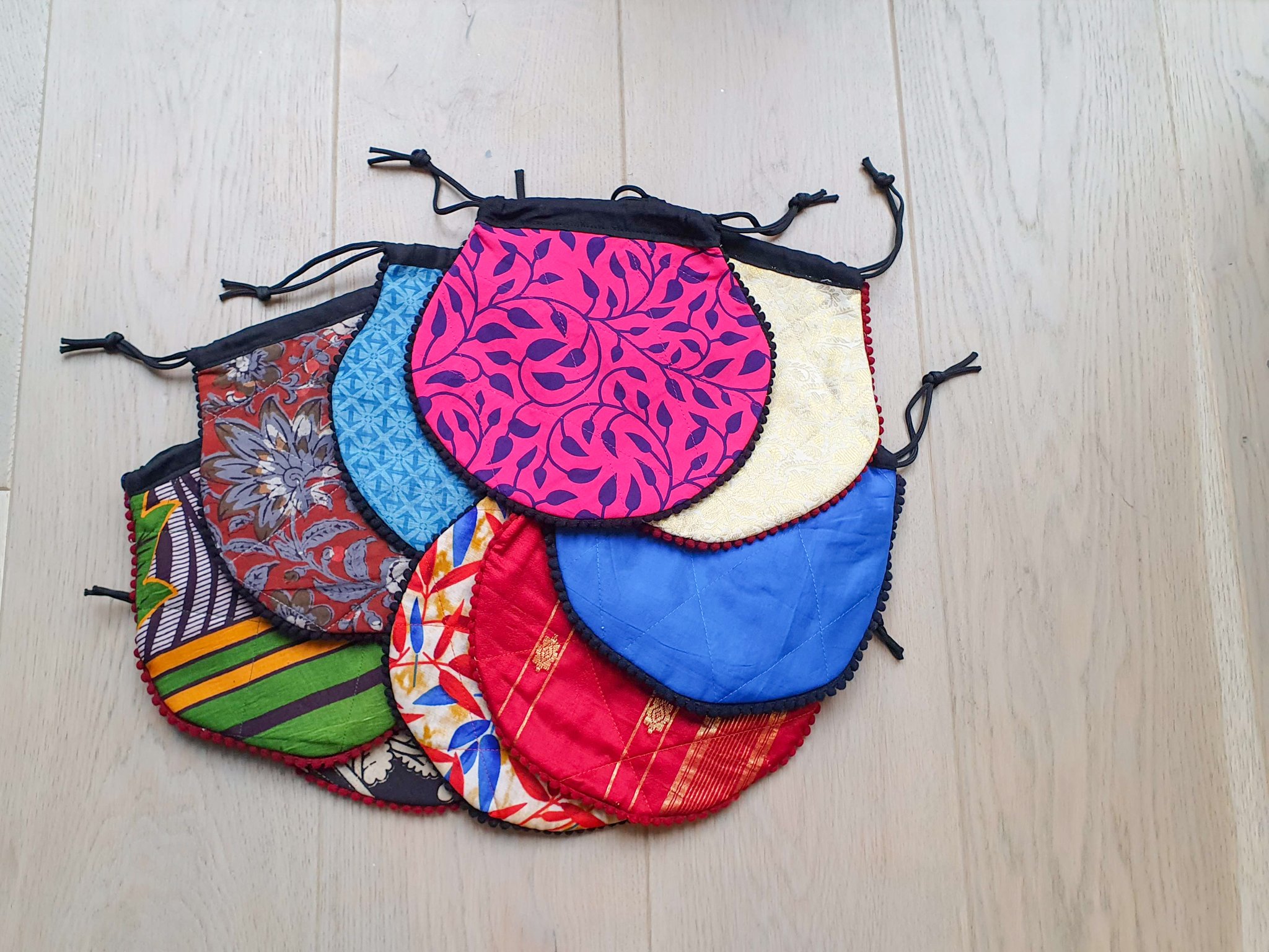 A colorful handcrafted drawstring sari pouch showcasing unique patterns and vibrant colors, perfect for storing small items.