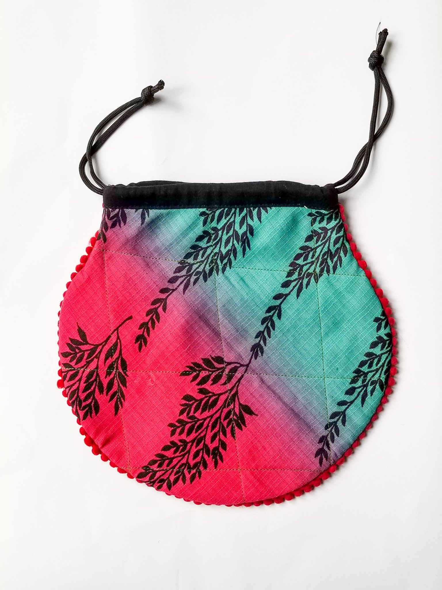 A colorful handcrafted drawstring sari pouch showcasing unique patterns and vibrant colors, perfect for storing small items.