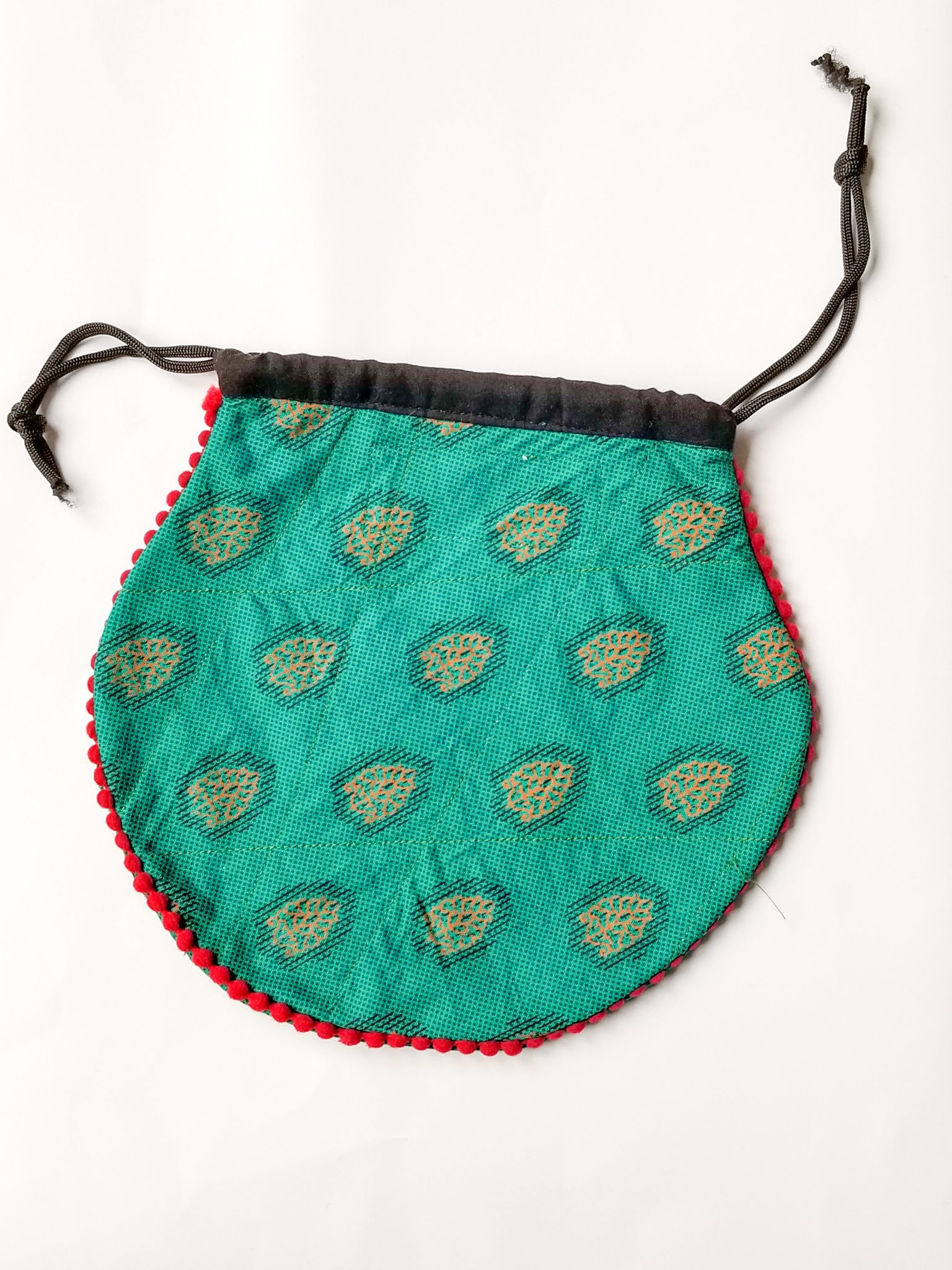 A colorful handcrafted drawstring sari pouch showcasing unique patterns and vibrant colors, perfect for storing small items.