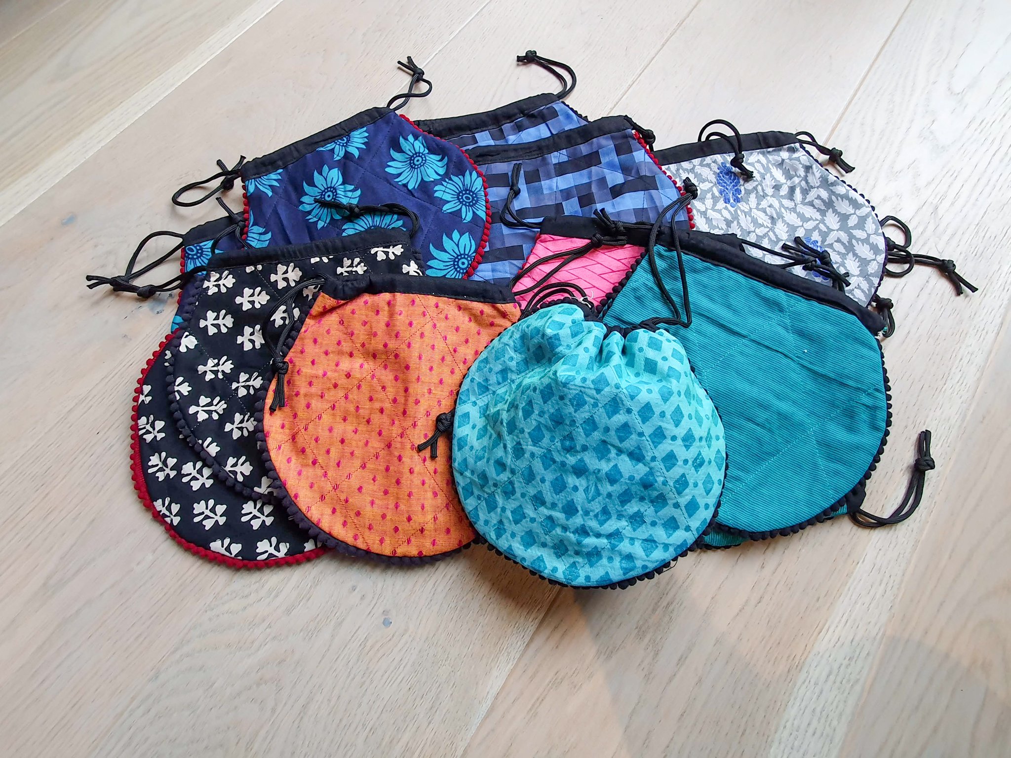 A colorful handcrafted drawstring sari pouch showcasing unique patterns and vibrant colors, perfect for storing small items.