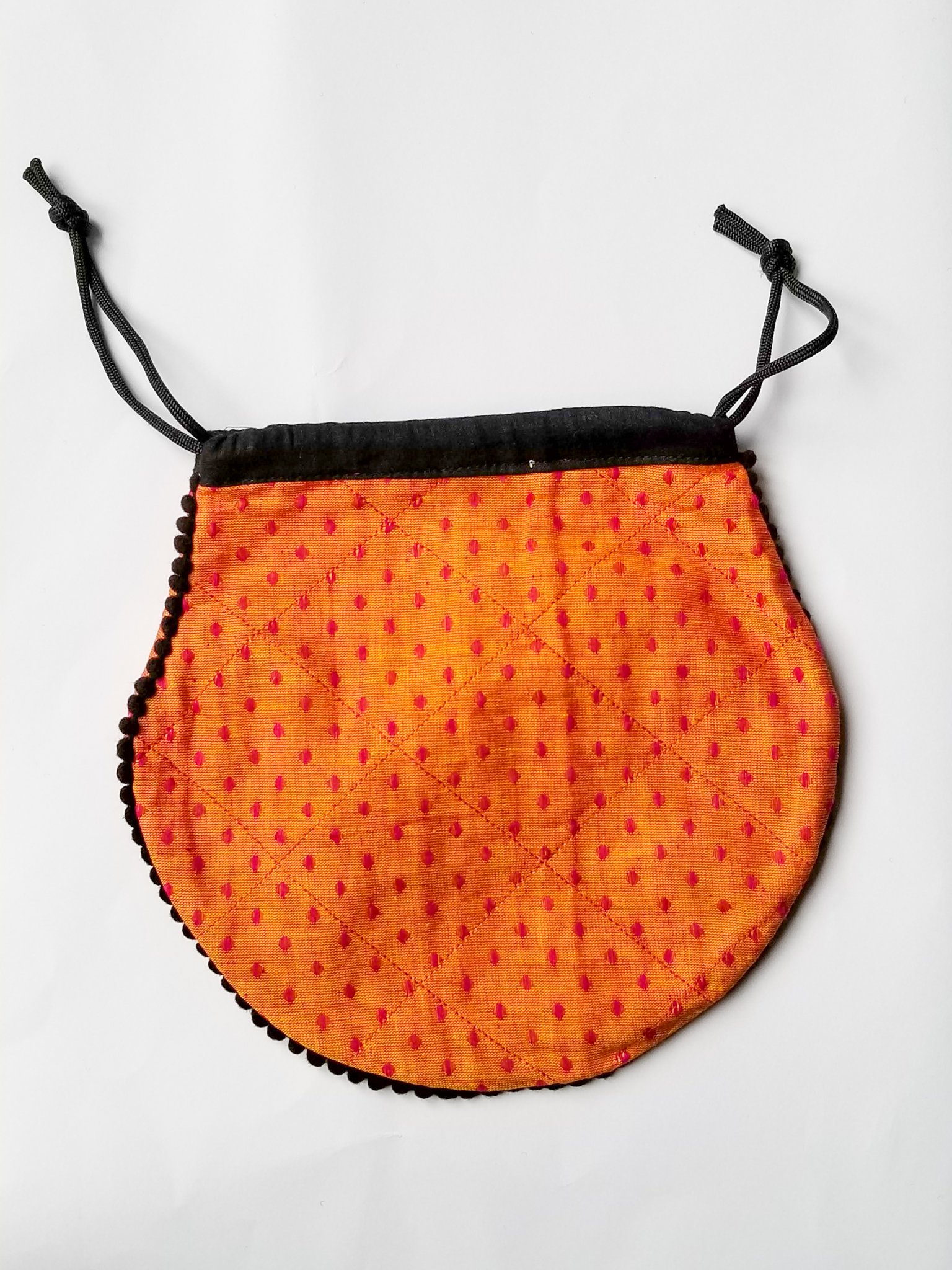 A colorful handcrafted drawstring sari pouch showcasing unique patterns and vibrant colors, perfect for storing small items.