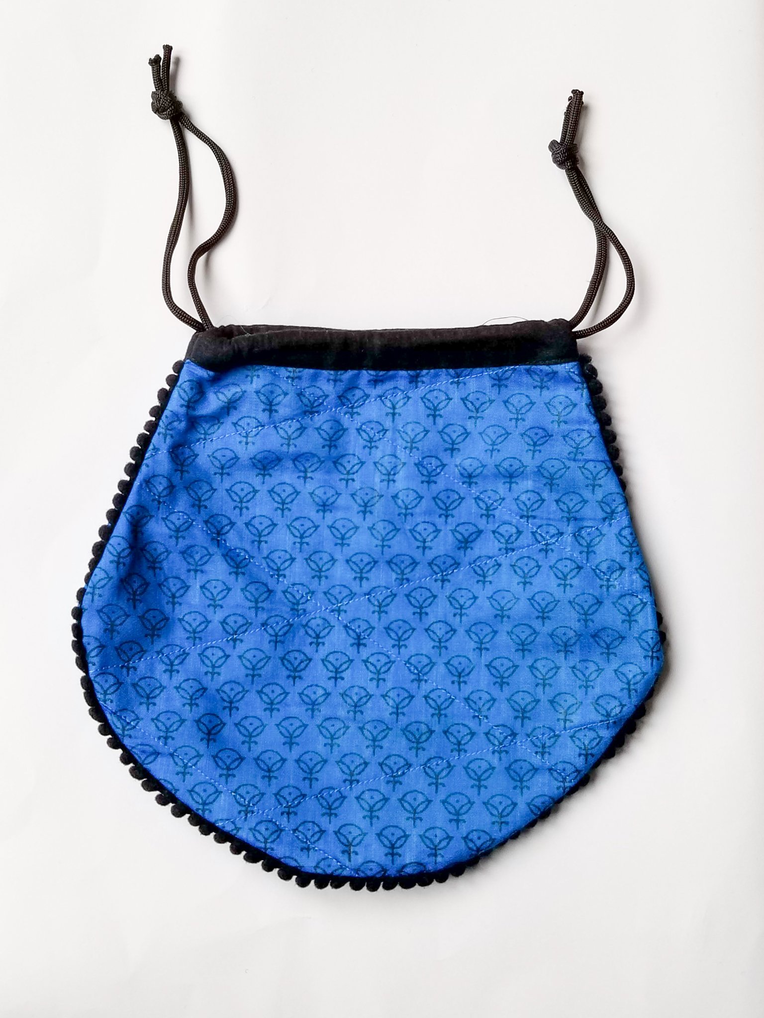 A colorful handcrafted drawstring sari pouch showcasing unique patterns and vibrant colors, perfect for storing small items.