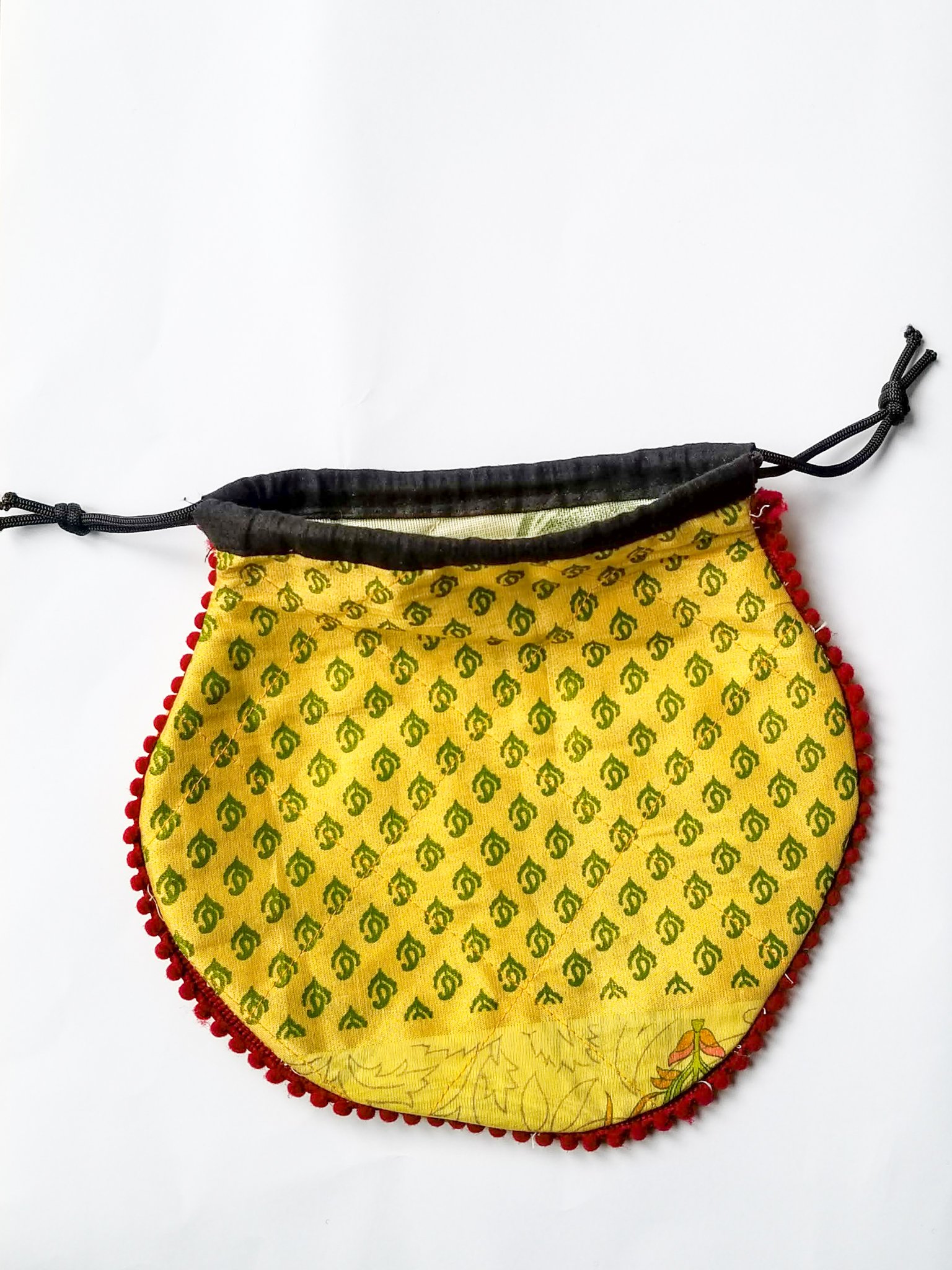 A colorful handcrafted drawstring sari pouch showcasing unique patterns and vibrant colors, perfect for storing small items.