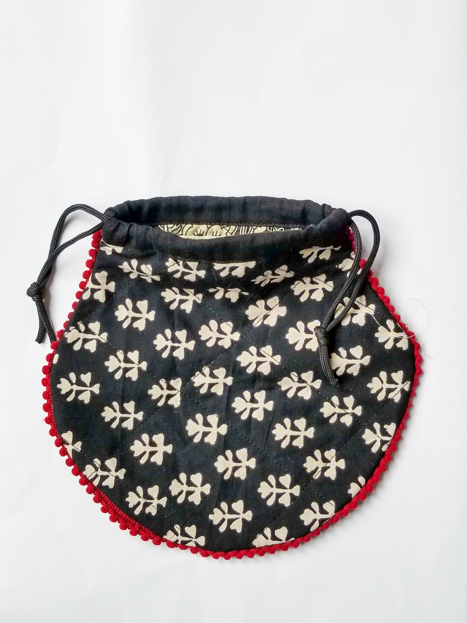 A colorful handcrafted drawstring sari pouch showcasing unique patterns and vibrant colors, perfect for storing small items.