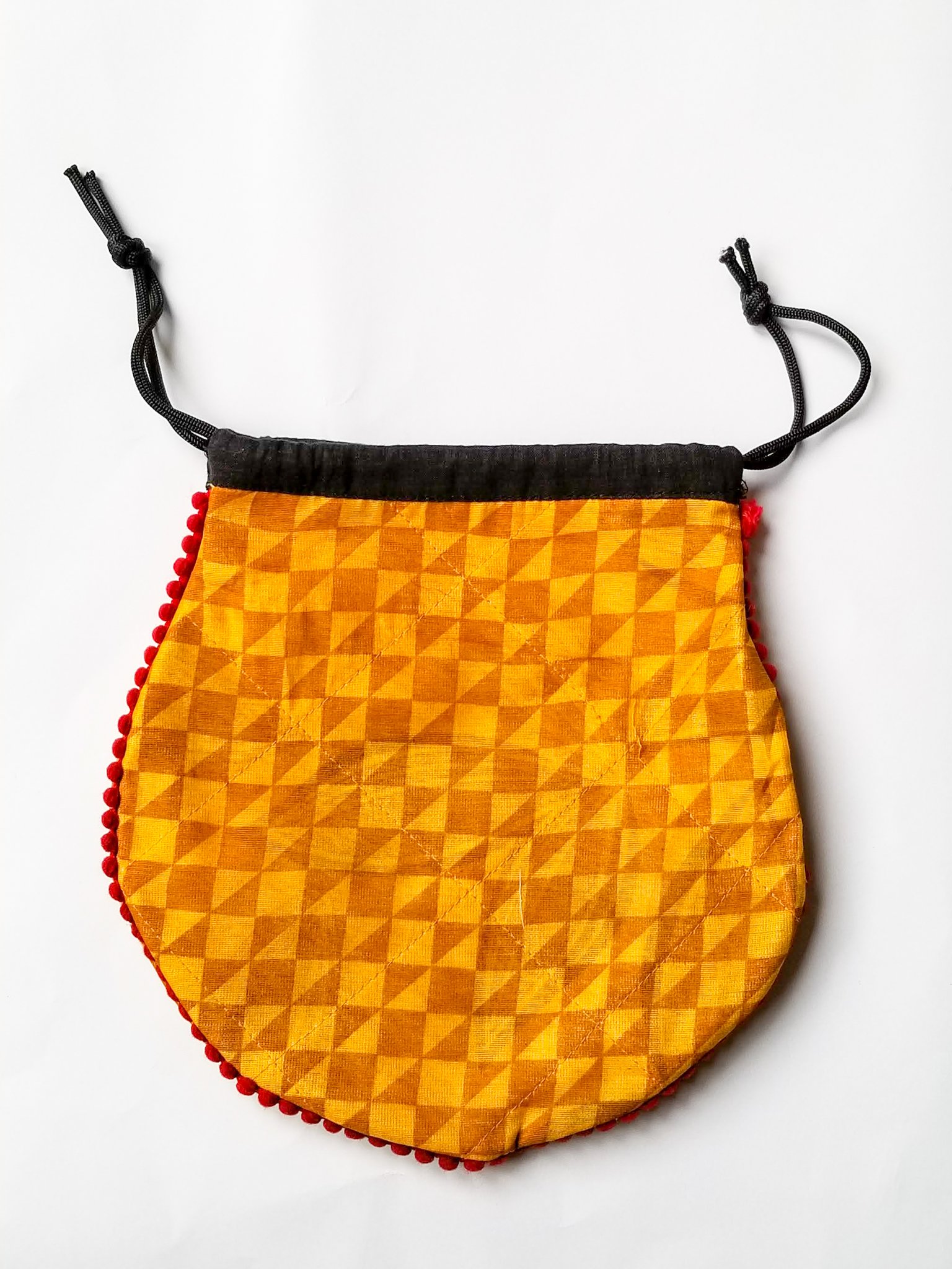 A colorful handcrafted drawstring sari pouch showcasing unique patterns and vibrant colors, perfect for storing small items.