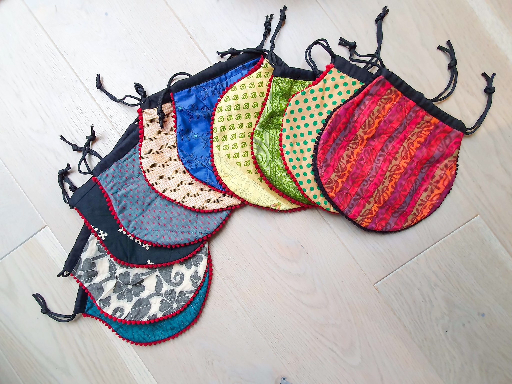 A colorful handcrafted drawstring sari pouch showcasing unique patterns and vibrant colors, perfect for storing small items.