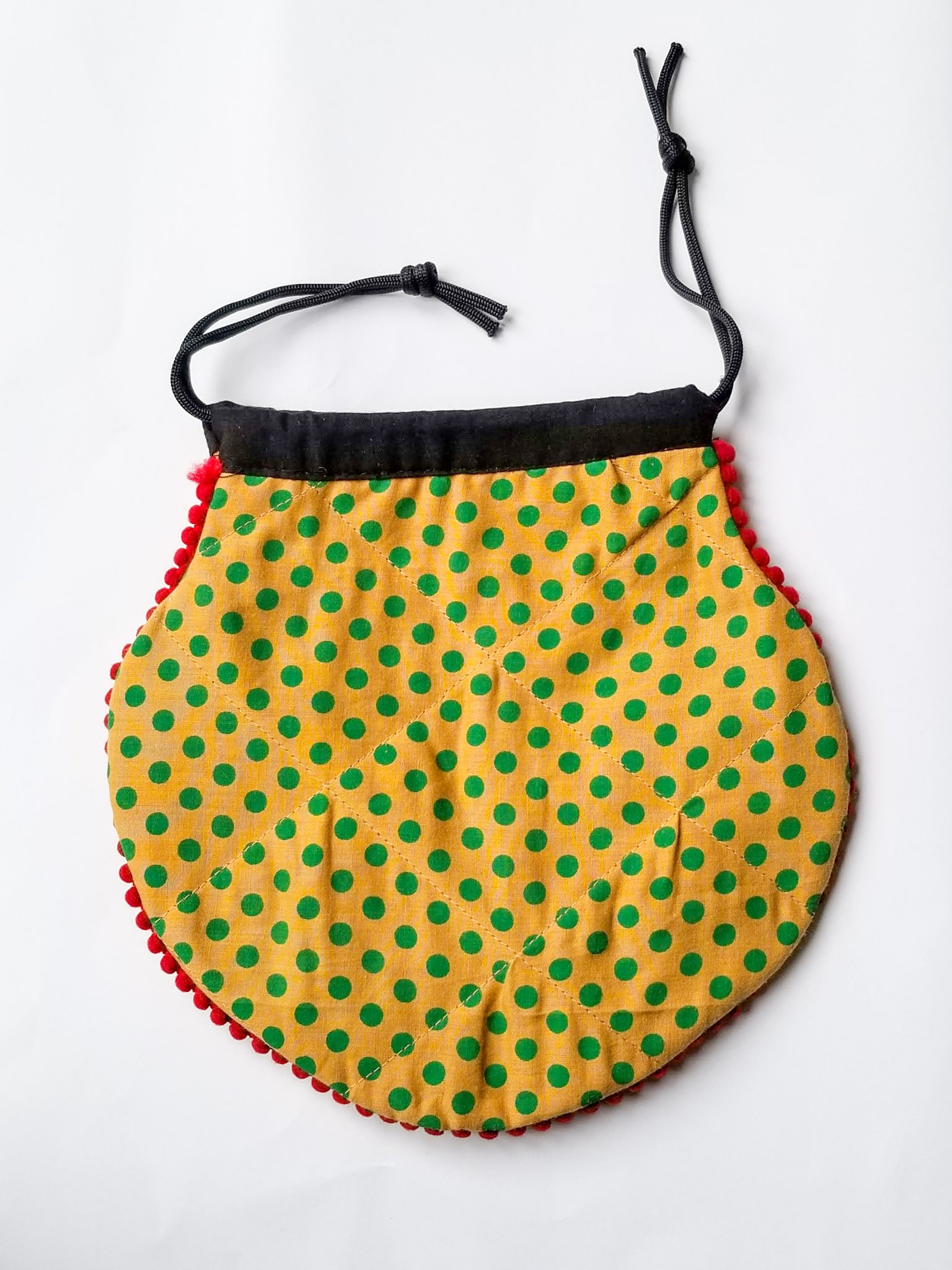 A colorful handcrafted drawstring sari pouch showcasing unique patterns and vibrant colors, perfect for storing small items.