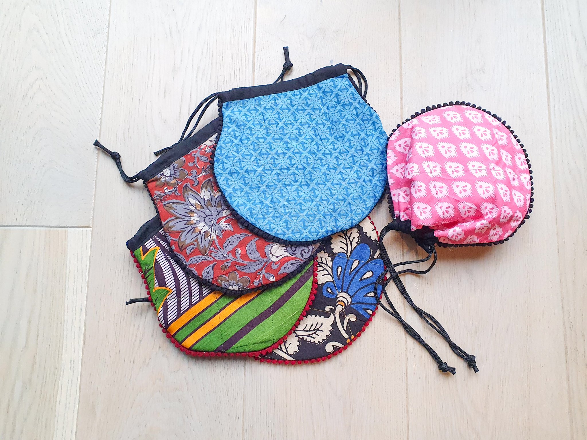 A colorful handcrafted drawstring sari pouch showcasing unique patterns and vibrant colors, perfect for storing small items.