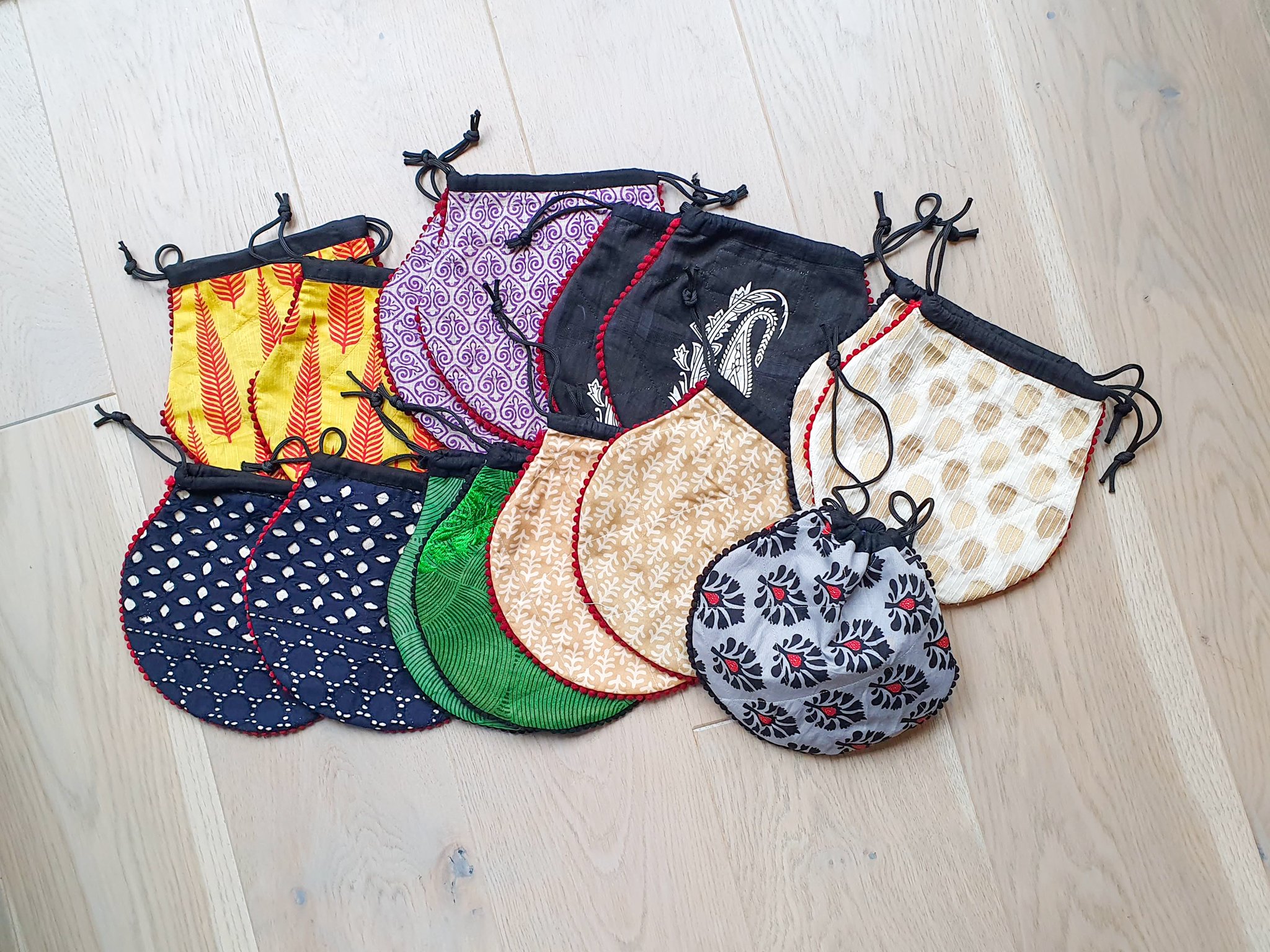 A colorful handcrafted drawstring sari pouch showcasing unique patterns and vibrant colors, perfect for storing small items.