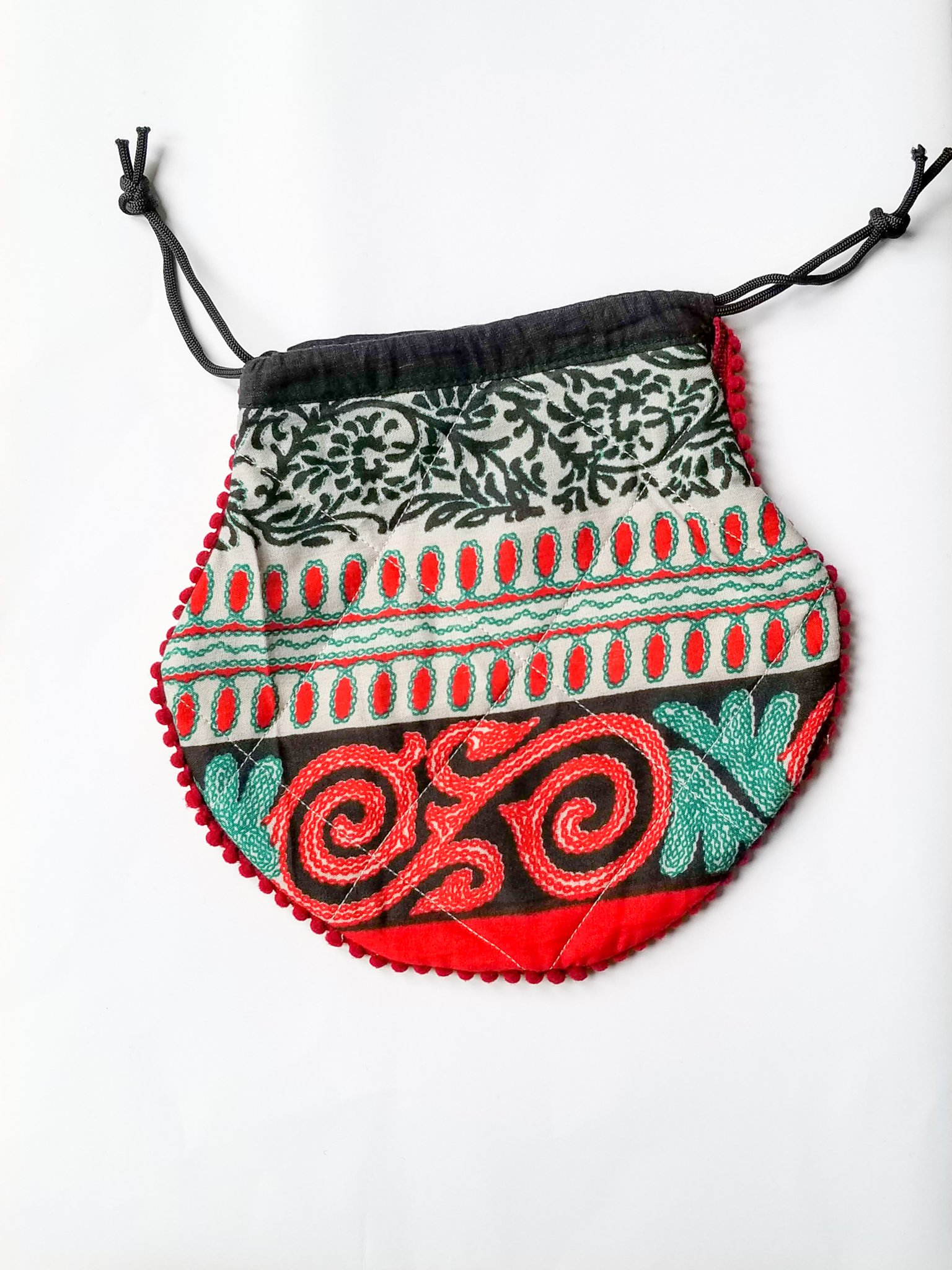 A colorful handcrafted drawstring sari pouch showcasing unique patterns and vibrant colors, perfect for storing small items.