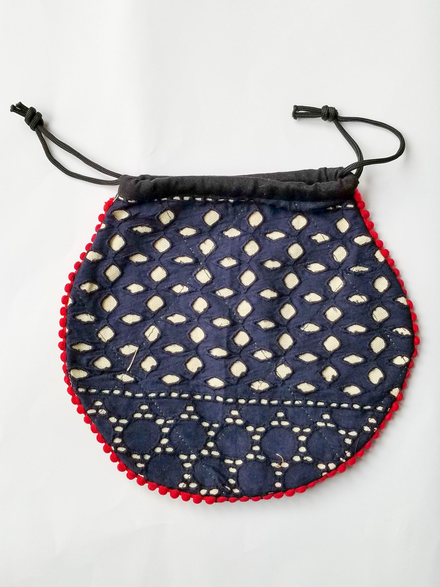 A colorful handcrafted drawstring sari pouch showcasing unique patterns and vibrant colors, perfect for storing small items.