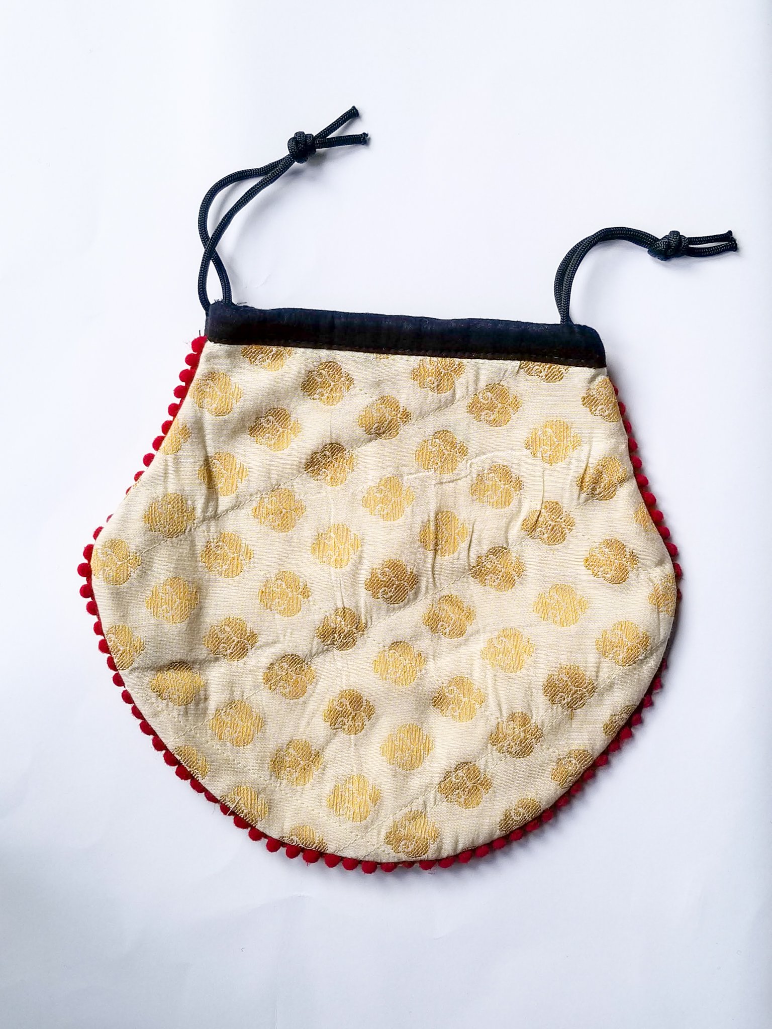 A colorful handcrafted drawstring sari pouch showcasing unique patterns and vibrant colors, perfect for storing small items.