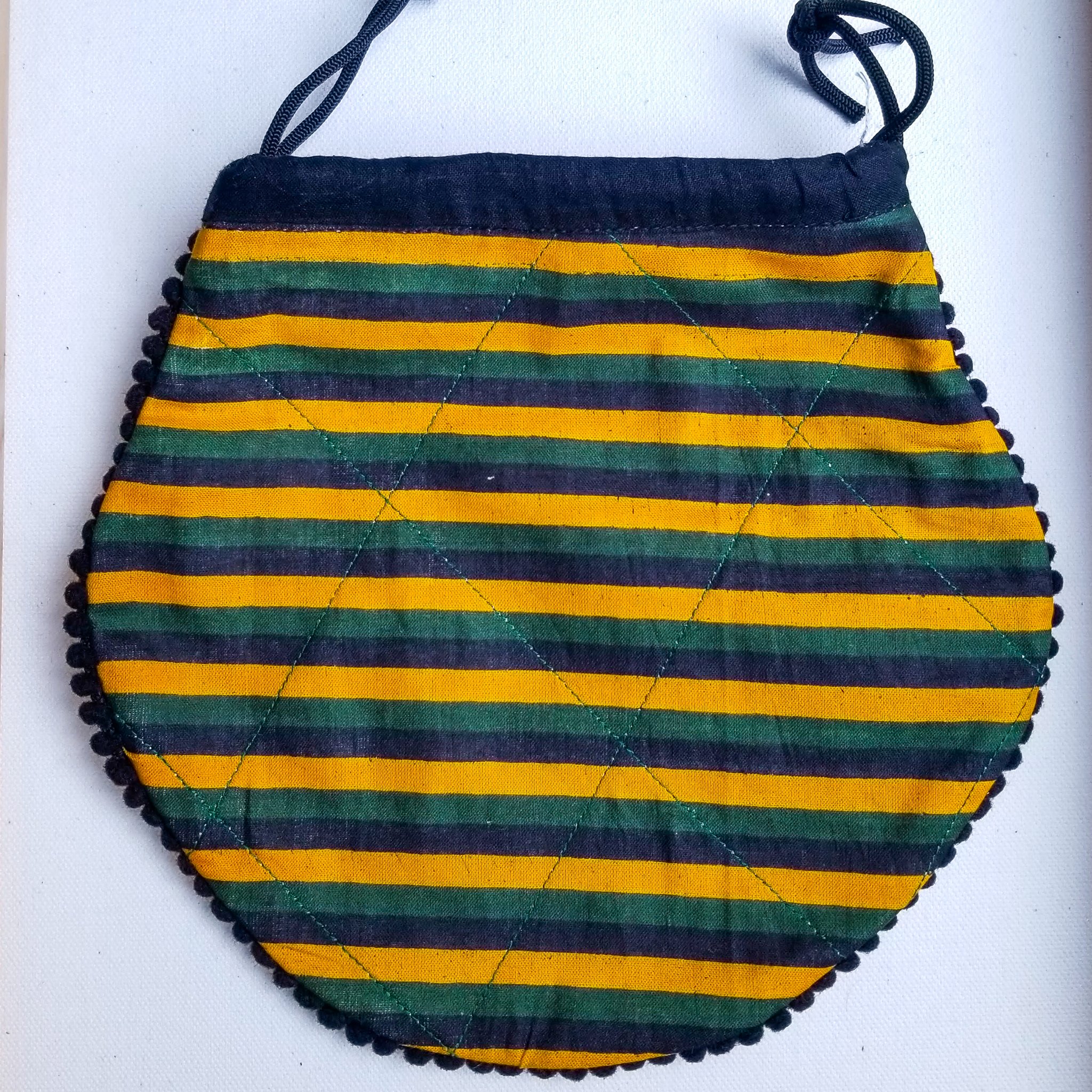 A colorful handcrafted drawstring sari pouch showcasing unique patterns and vibrant colors, perfect for storing small items.