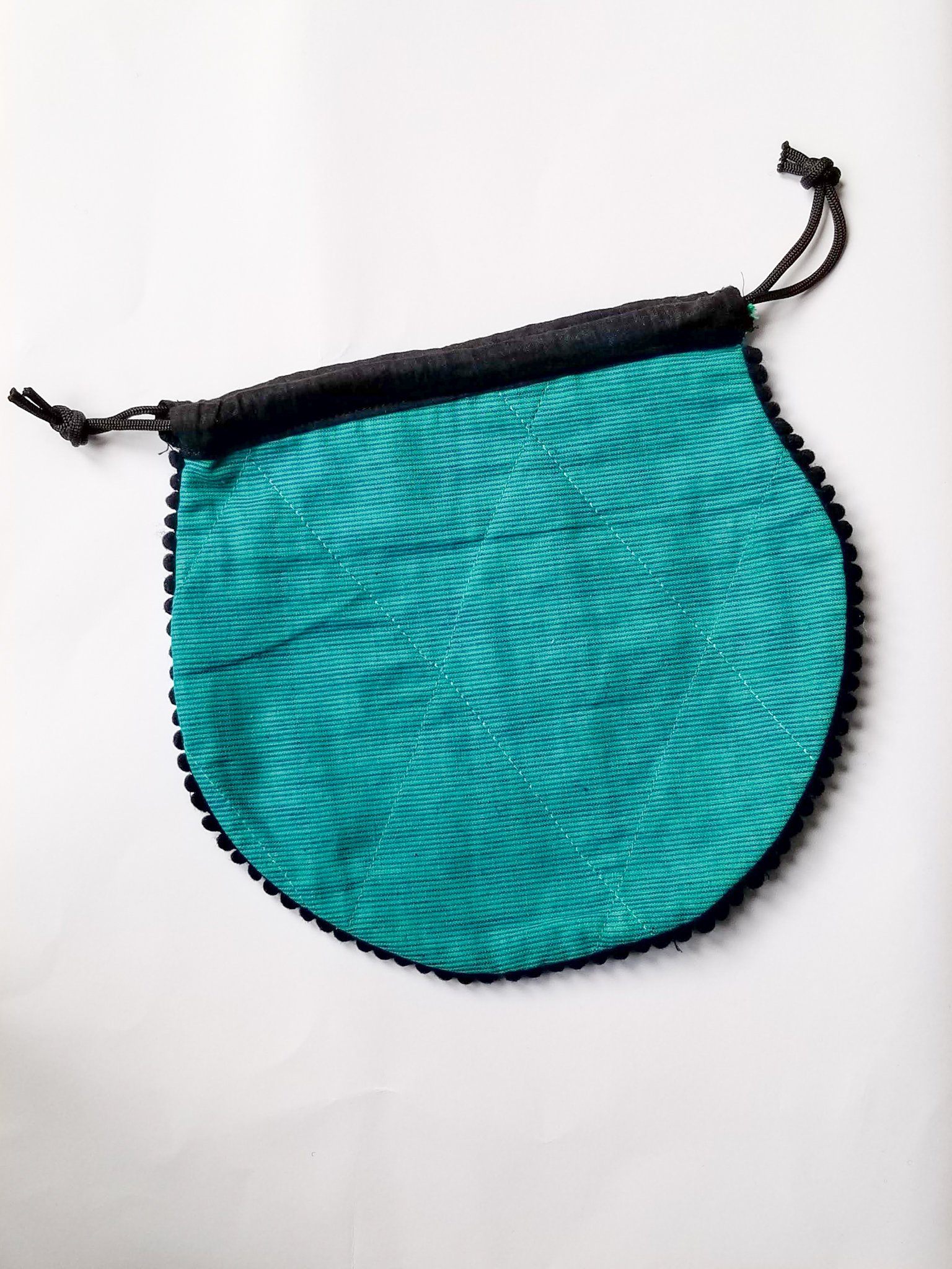 A colorful handcrafted drawstring sari pouch showcasing unique patterns and vibrant colors, perfect for storing small items.