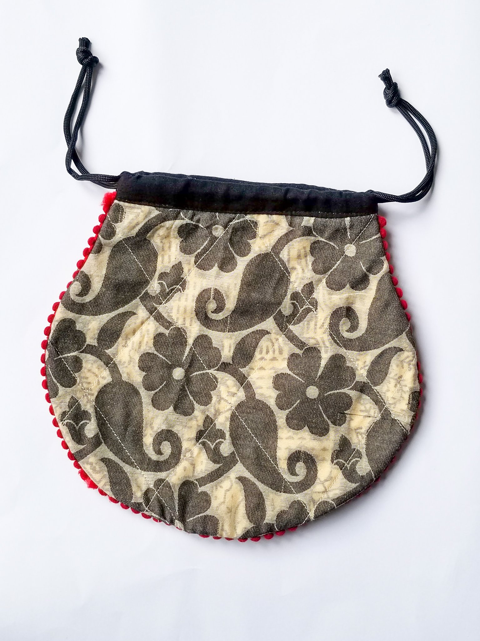 A colorful handcrafted drawstring sari pouch showcasing unique patterns and vibrant colors, perfect for storing small items.