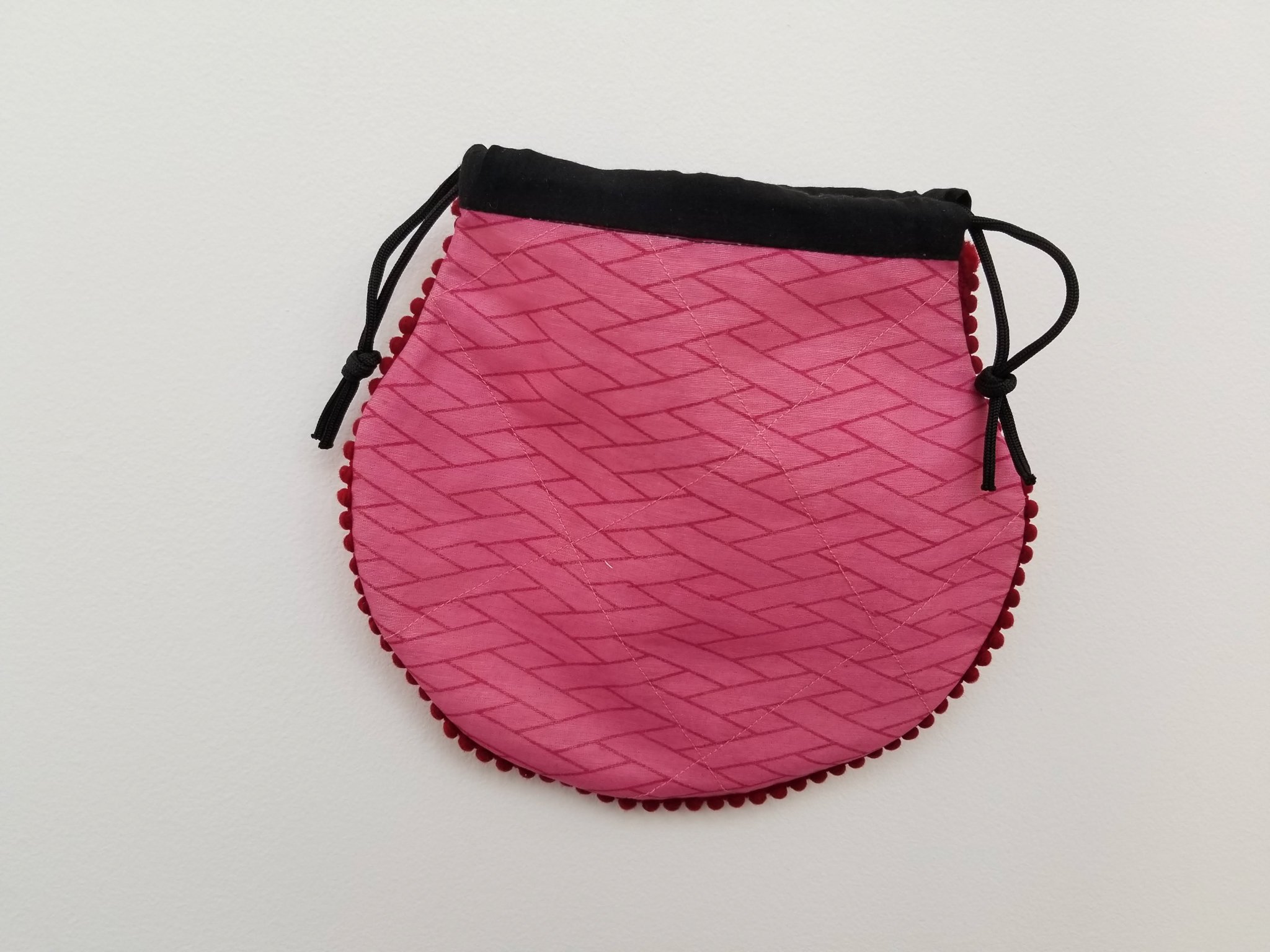 A colorful handcrafted drawstring sari pouch showcasing unique patterns and vibrant colors, perfect for storing small items.