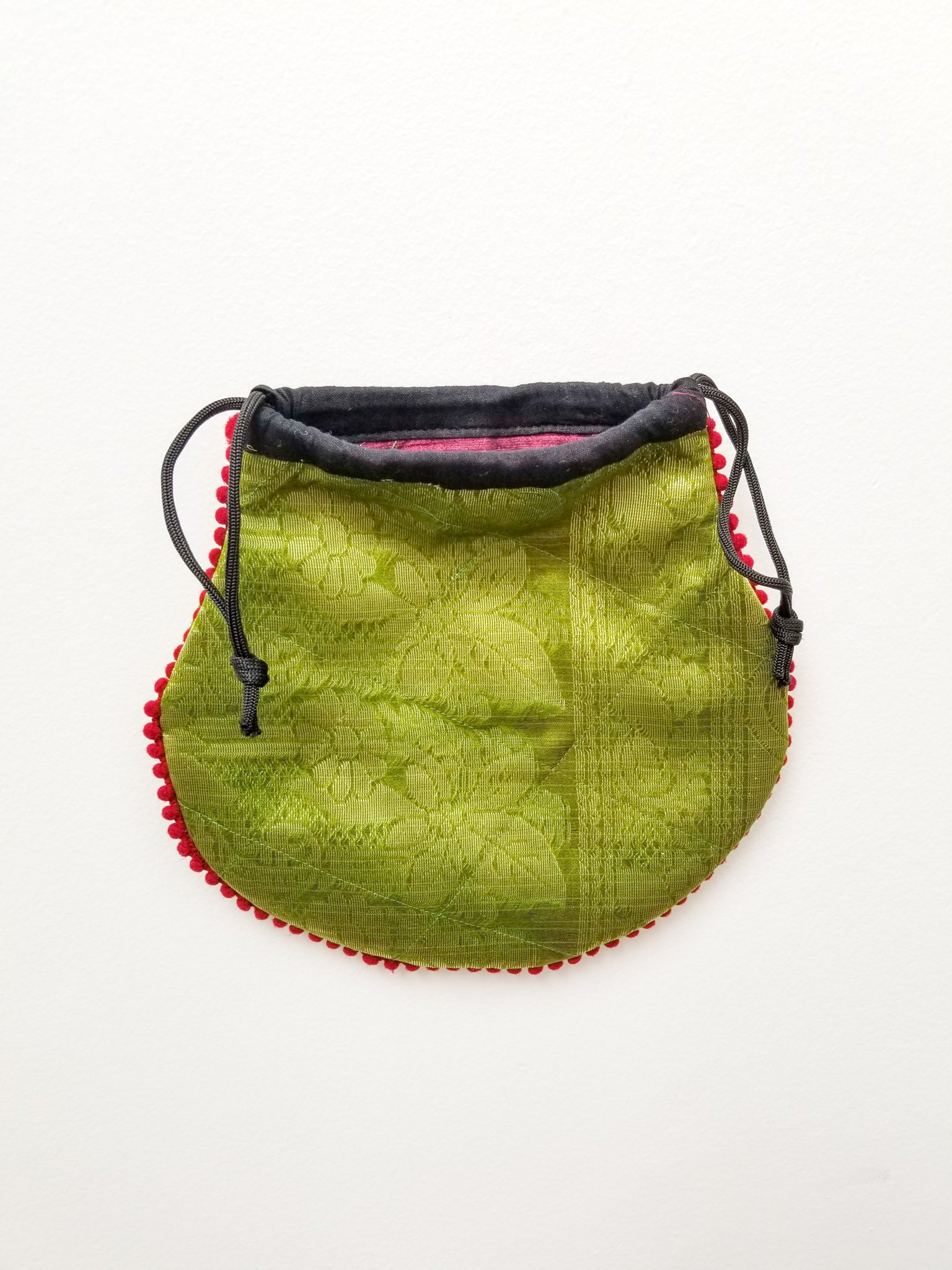 A colorful handcrafted drawstring sari pouch showcasing unique patterns and vibrant colors, perfect for storing small items.