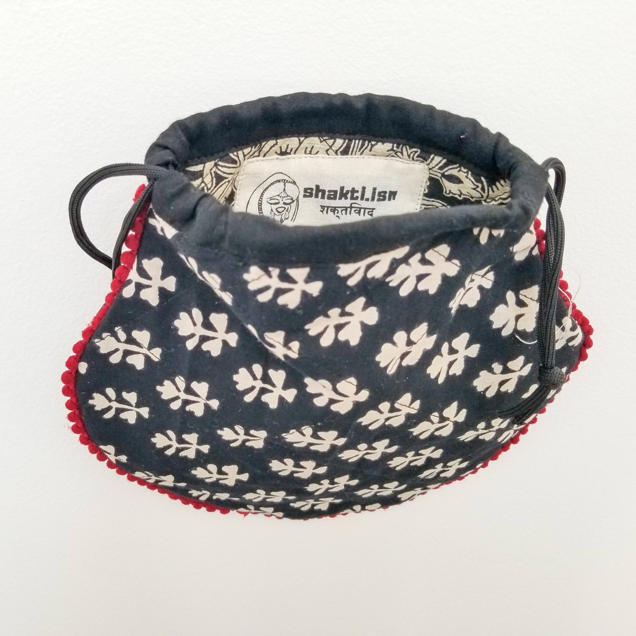 A colorful handcrafted drawstring sari pouch showcasing unique patterns and vibrant colors, perfect for storing small items.