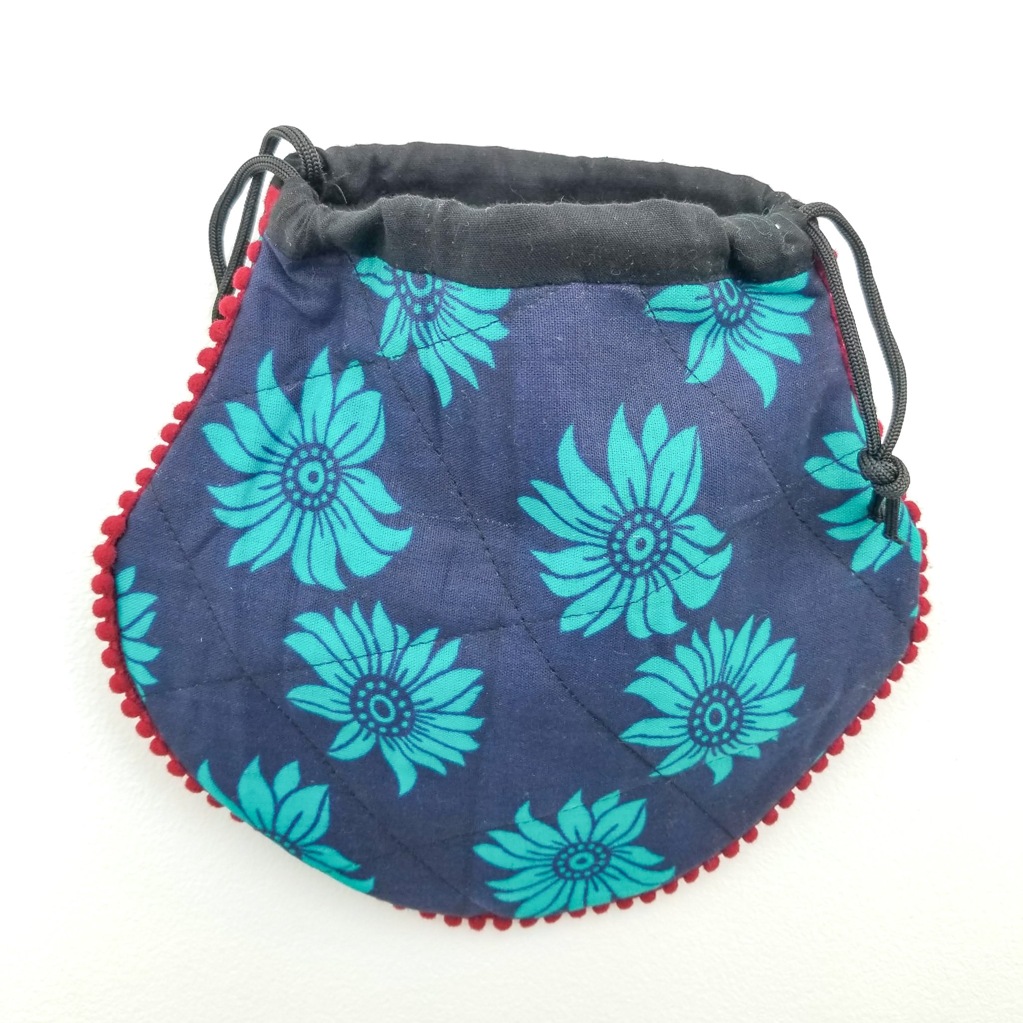 A colorful handcrafted drawstring sari pouch showcasing unique patterns and vibrant colors, perfect for storing small items.