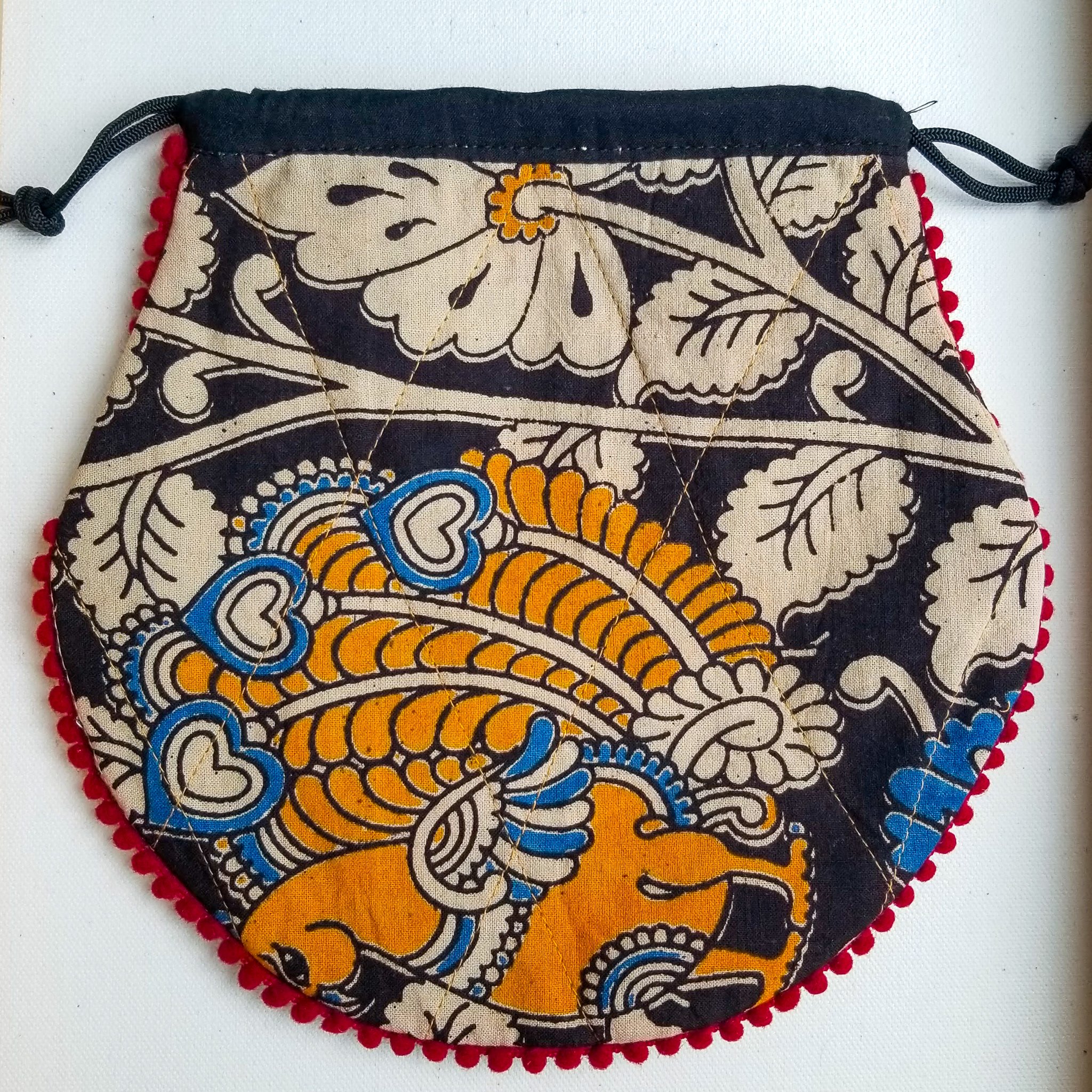 A colorful handcrafted drawstring sari pouch showcasing unique patterns and vibrant colors, perfect for storing small items.