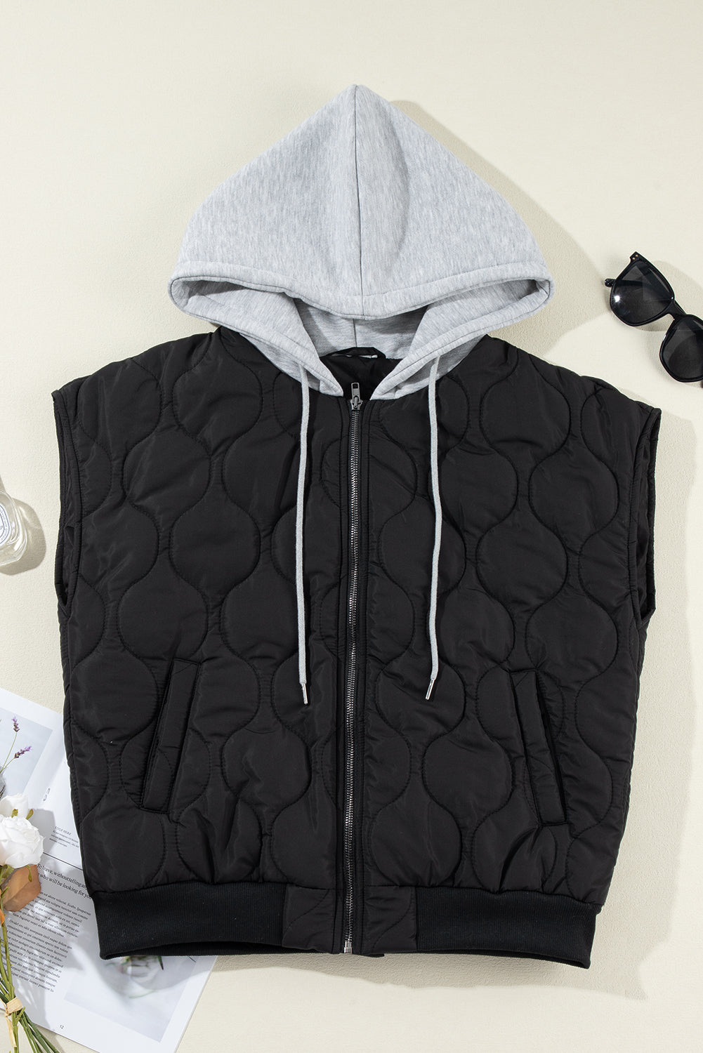 A stylish drawstring zip-up hooded vest coat in black, showcasing its adjustable drawstring and sleek design.