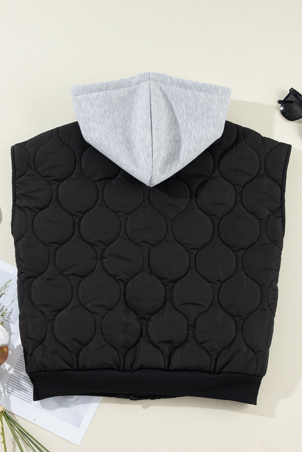 A stylish drawstring zip-up hooded vest coat in black, showcasing its adjustable drawstring and sleek design.