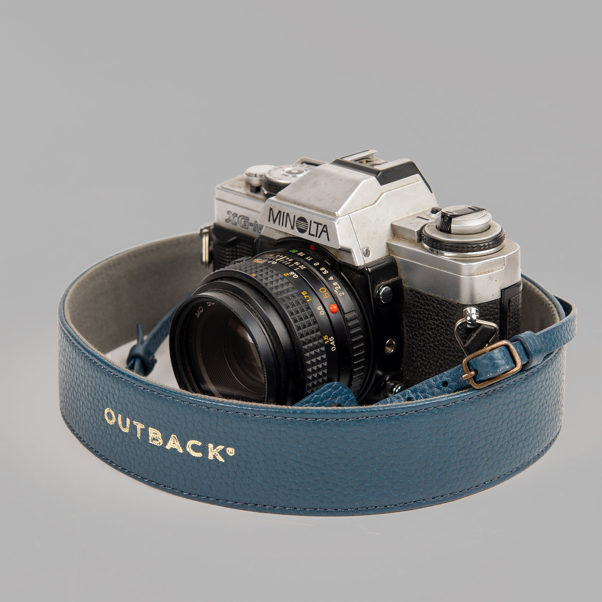 A stylish DSLR camera leather strap made from durable harness leather with antique brass hardware, showcasing its adjustable length and metal rings.