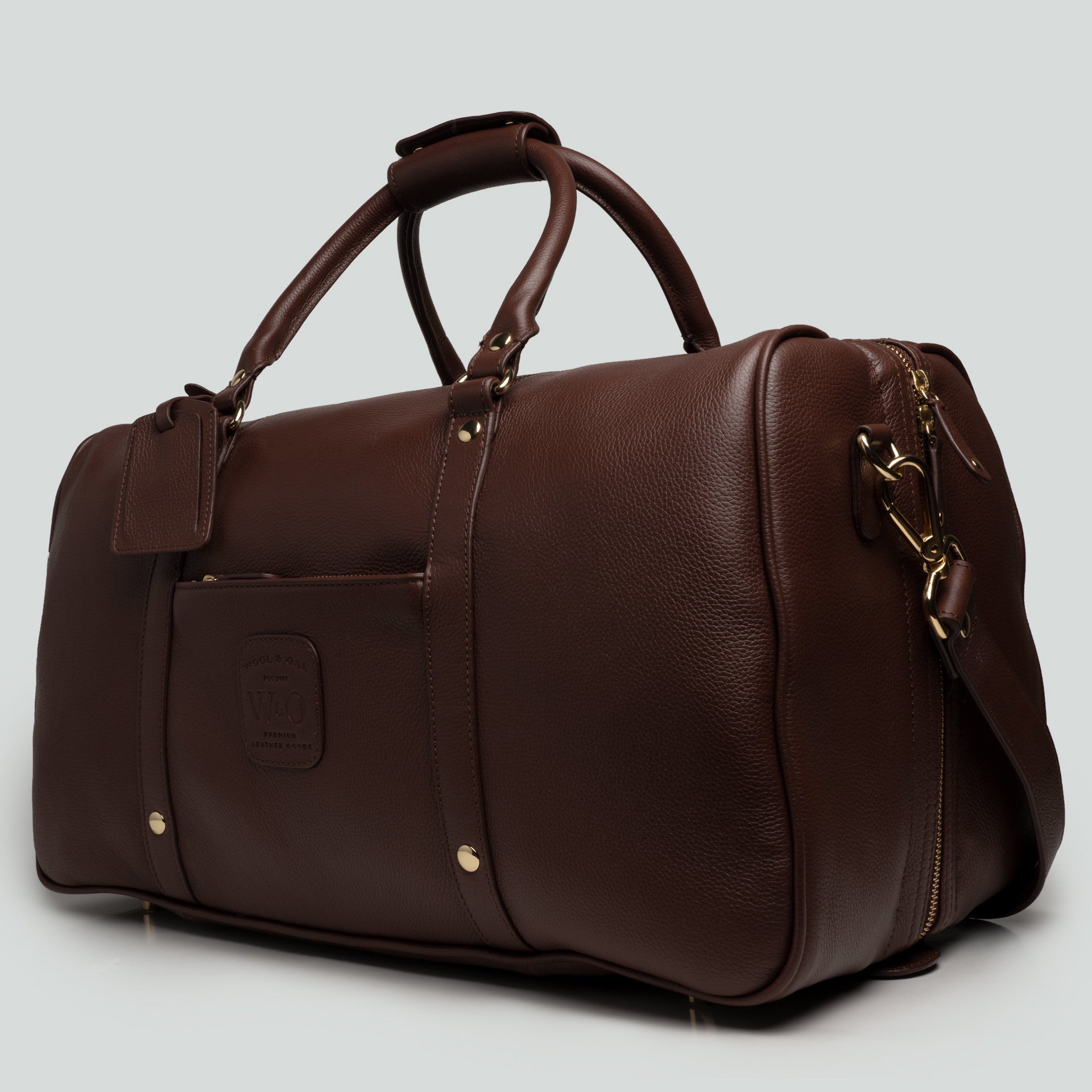 A stylish Duffle Suitcase 20" made of full grain leather with brass hardware, featuring removable walls for customizable compartments.