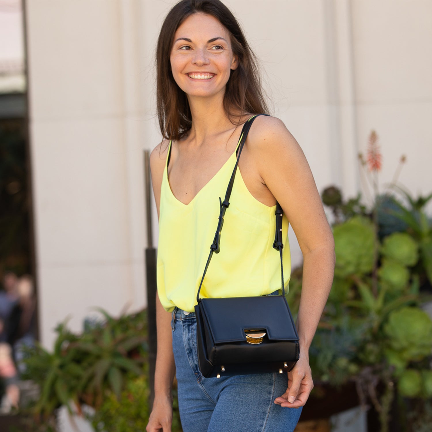 Elizabeth Black Leather Saddle Bag featuring a geometric shape, gold hardware, and adjustable strap, perfect for stylish organization.