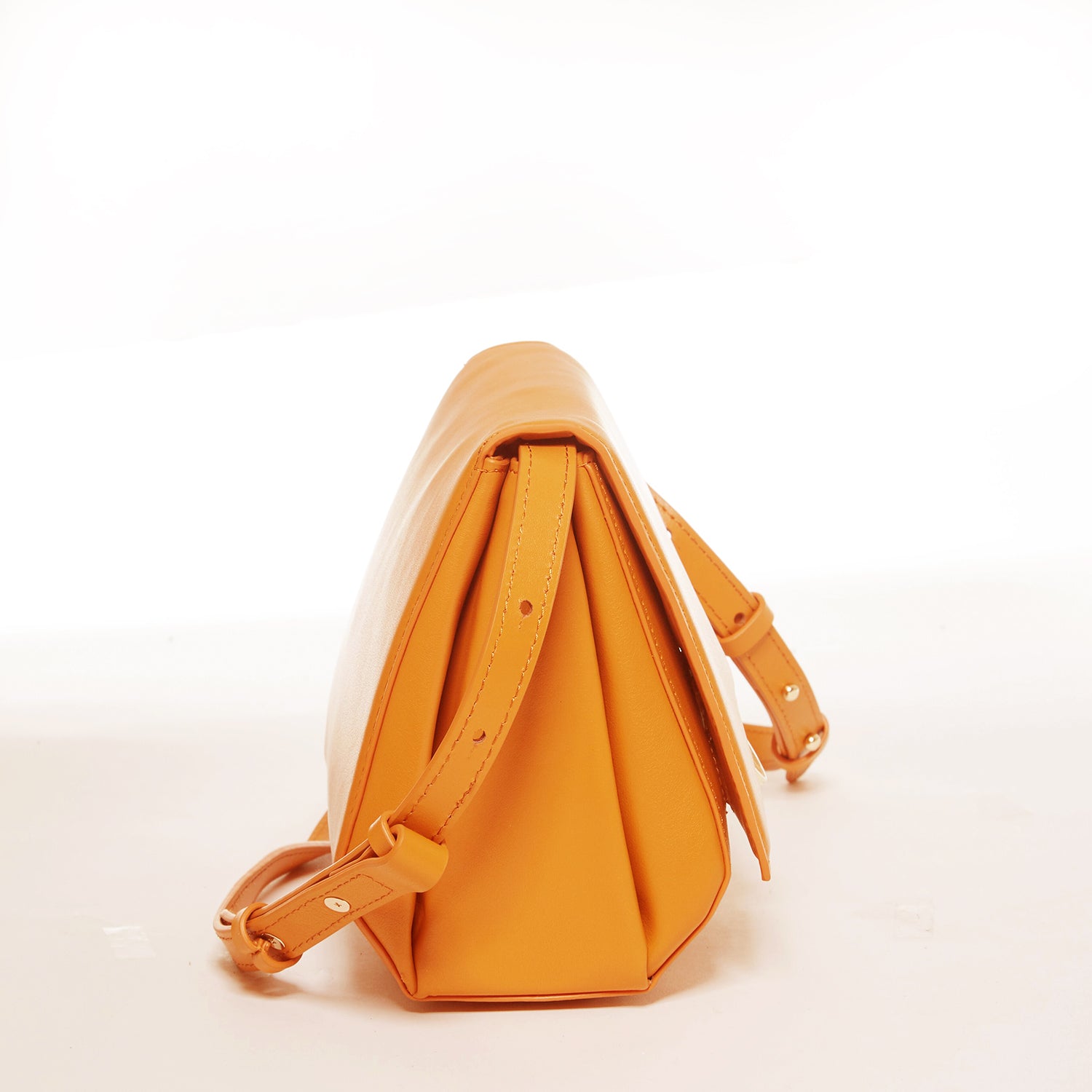 Elizabeth Dark Orange Leather Saddle Bag with gold hardware and adjustable strap, showcasing its geometric shape and teal interior.