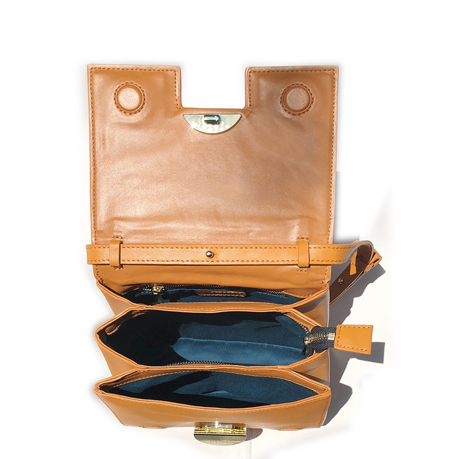 Elizabeth Dark Orange Leather Saddle Bag with gold hardware and adjustable strap, showcasing its geometric shape and teal interior.