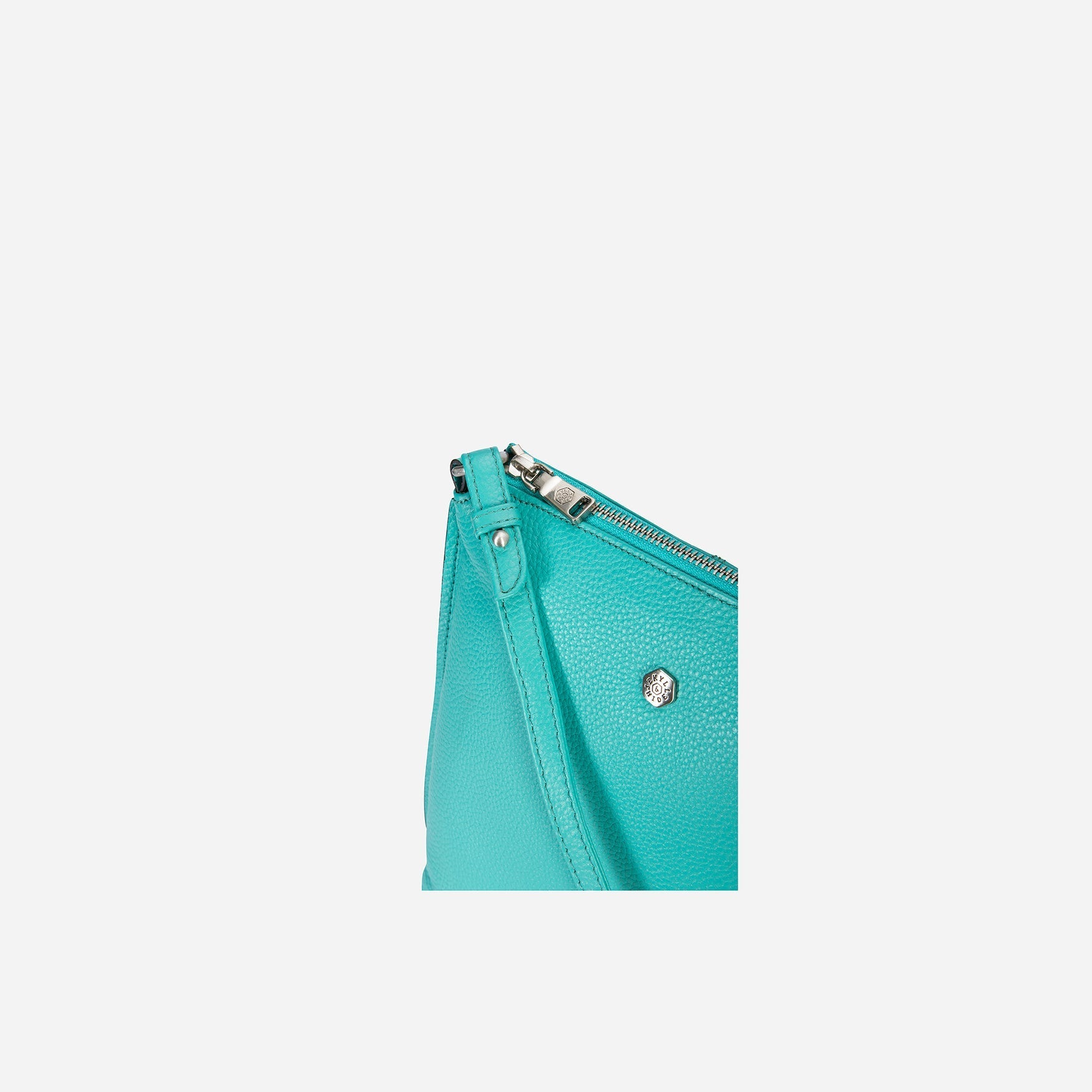 Essentials Crossbody Bag in Calypso Teal, showcasing its stylish design and textured material.