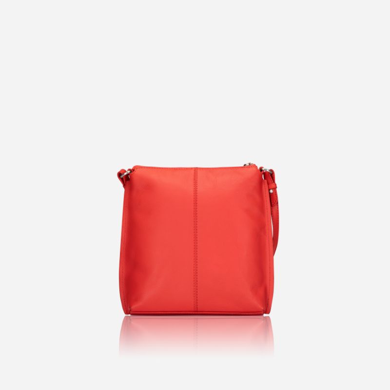 Essentials Crossbody bag in vibrant Candy Apple leather, showcasing its stylish design and adjustable strap.