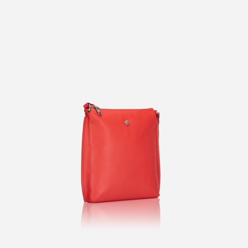 Essentials Crossbody bag in vibrant Candy Apple leather, showcasing its stylish design and adjustable strap.