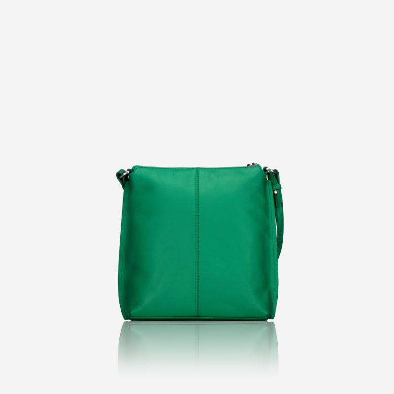 Essentials Crossbody bag in vibrant Spring Basil leather, showcasing its stylish design and adjustable strap.